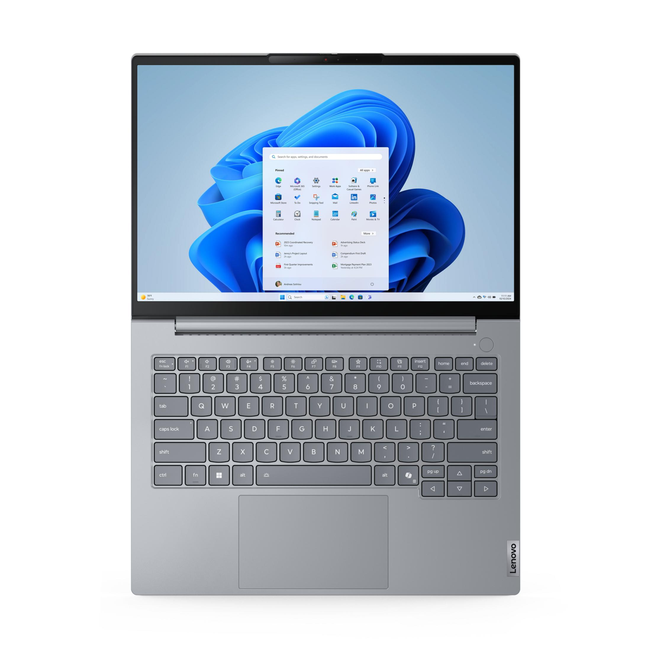 Srebrny laptop z otwartym ekranem, wyświetlający menu Start systemu Windows 11.