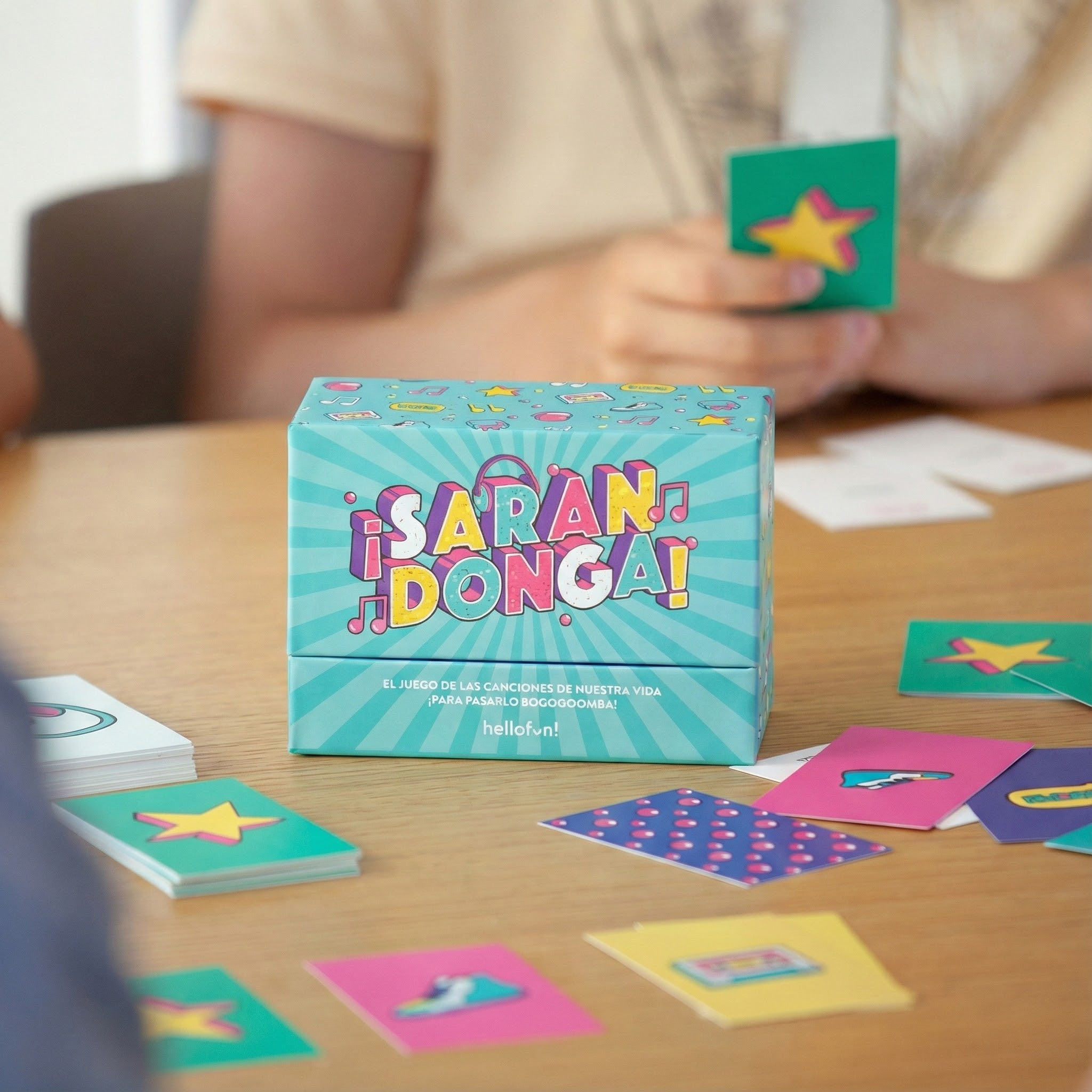 Una caja de juego con cartas coloridas sobre una mesa de madera.