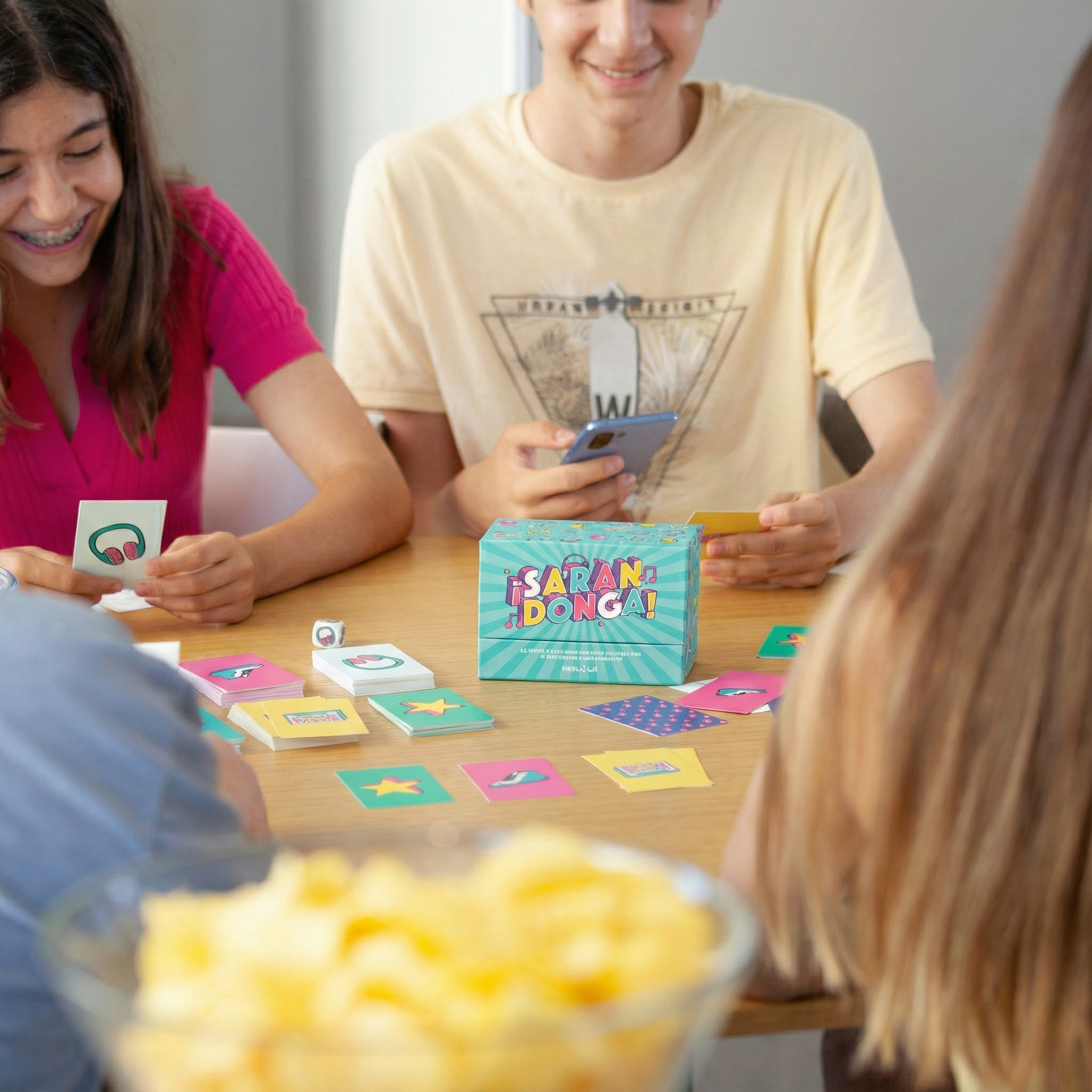 Niños jugando a un juego de cartas con cartas coloridas y una caja de juego.
