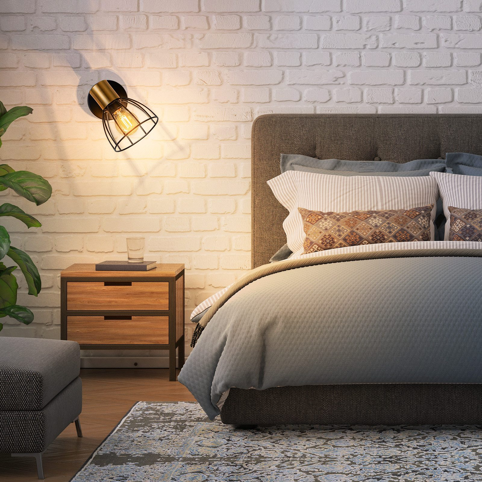 Una camera da letto con muro in mattoni bianchi, comodino, letto e lampada.