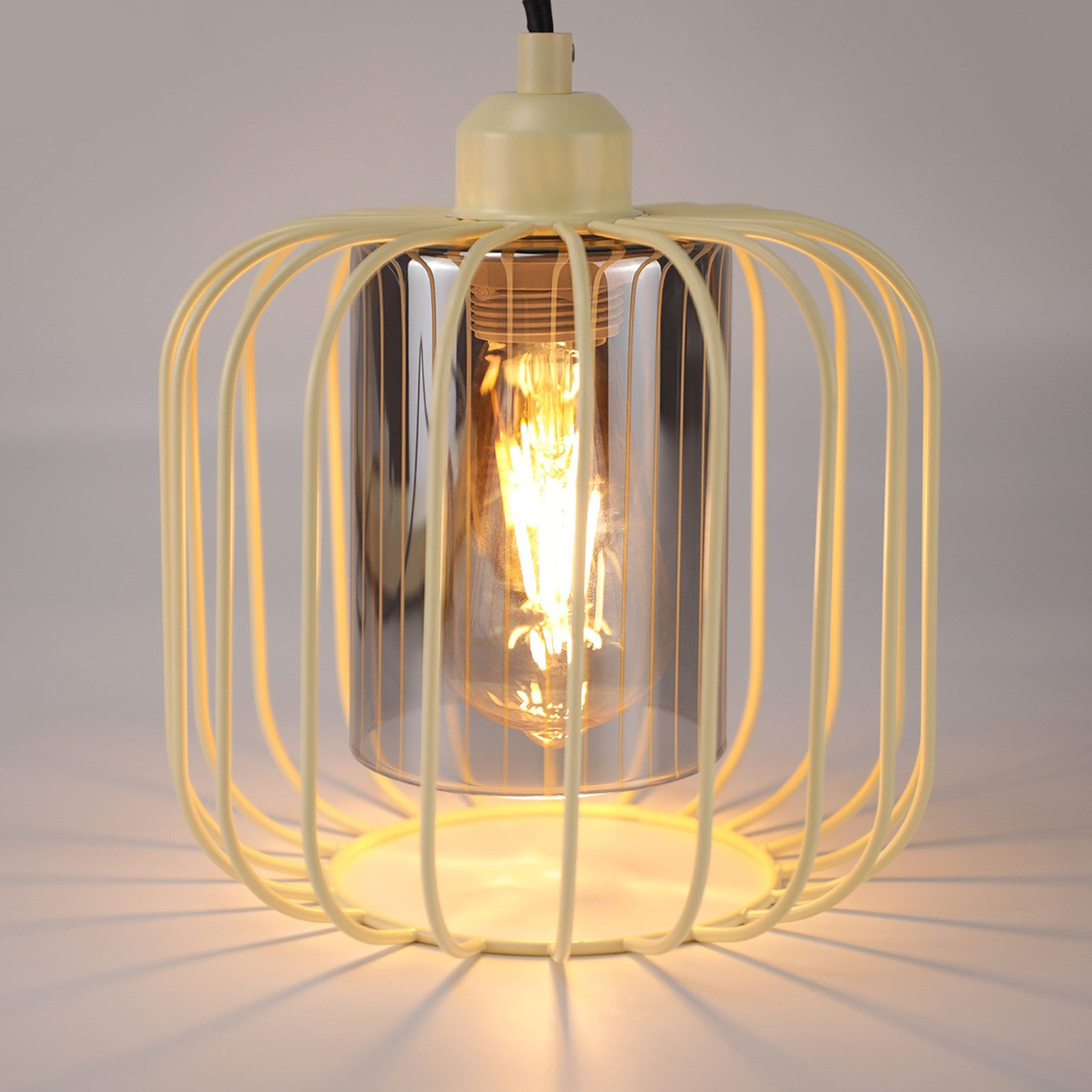Una lampada a gabbia gialla con cilindro trasparente e lampadina.