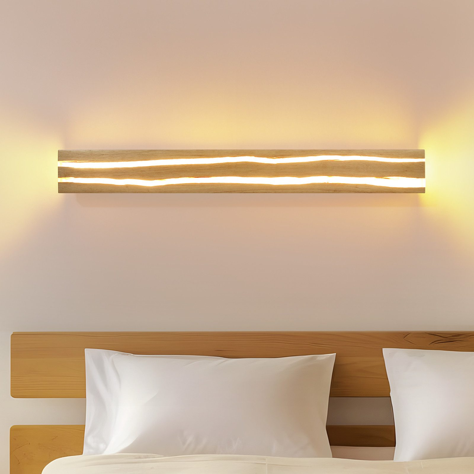 Lampada in legno con due strisce luminose sopra un letto con cuscini bianchi.