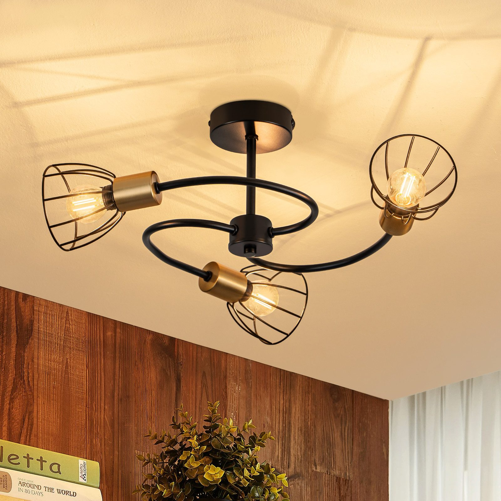 Lampadario da soffitto nero con tre paralumi a gabbia e accenti dorati.