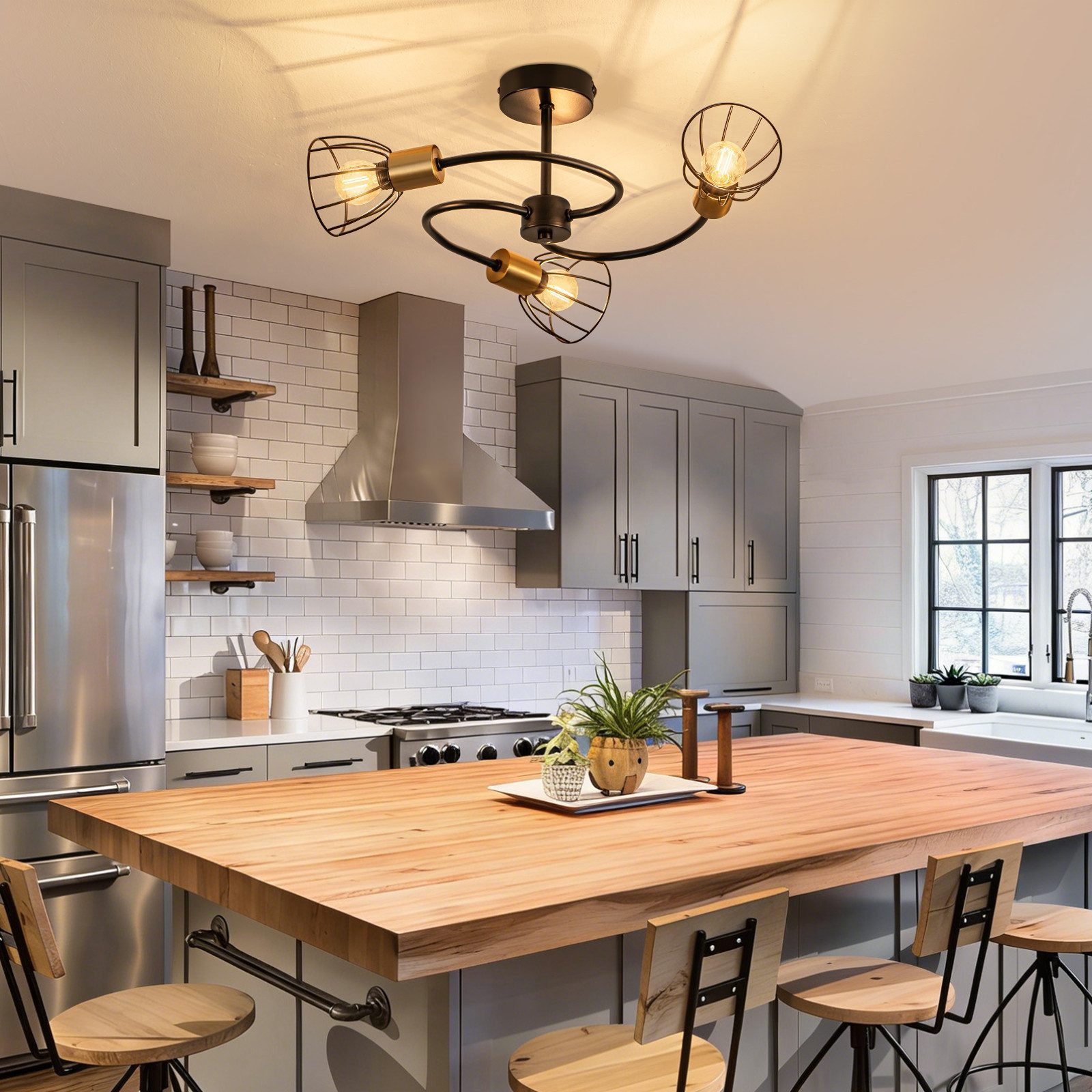 Cucina moderna con isola in legno, elettrodomestici in metallo e lampade a sospensione.