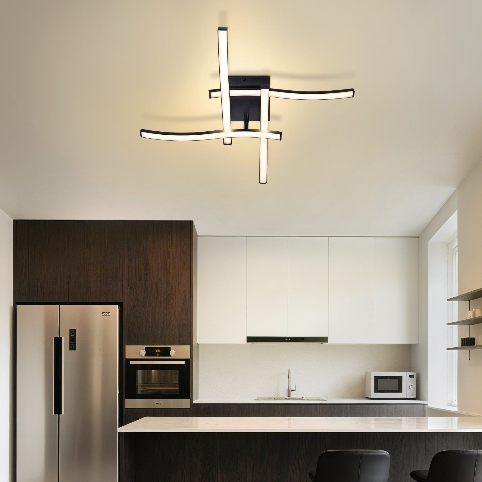 Cucina moderna con frigorifero in acciaio inox, forno e plafoniera.