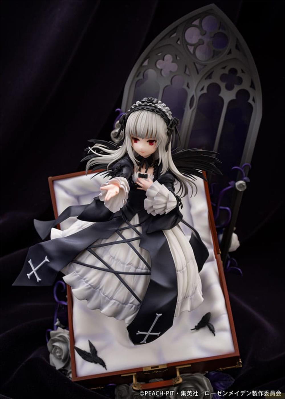Eine Gothic-Puppe in einem Sarg mit schwarzen Flügeln und roten Augen.