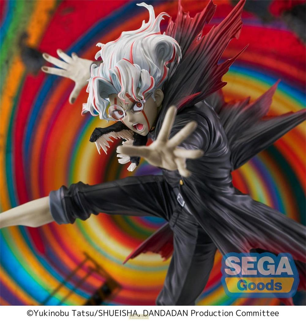 Una figura con pelo blanco y rojo, vestida de negro y rojo, ante un fondo colorido.