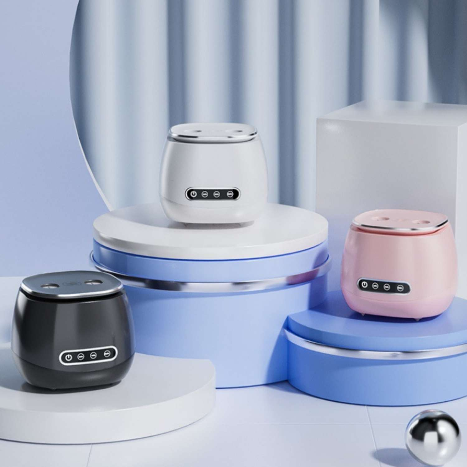 Drei kleine, moderne elektronische Geräte in Schwarz, Weiß und Pink stehen auf blauen und weißen Podesten.
