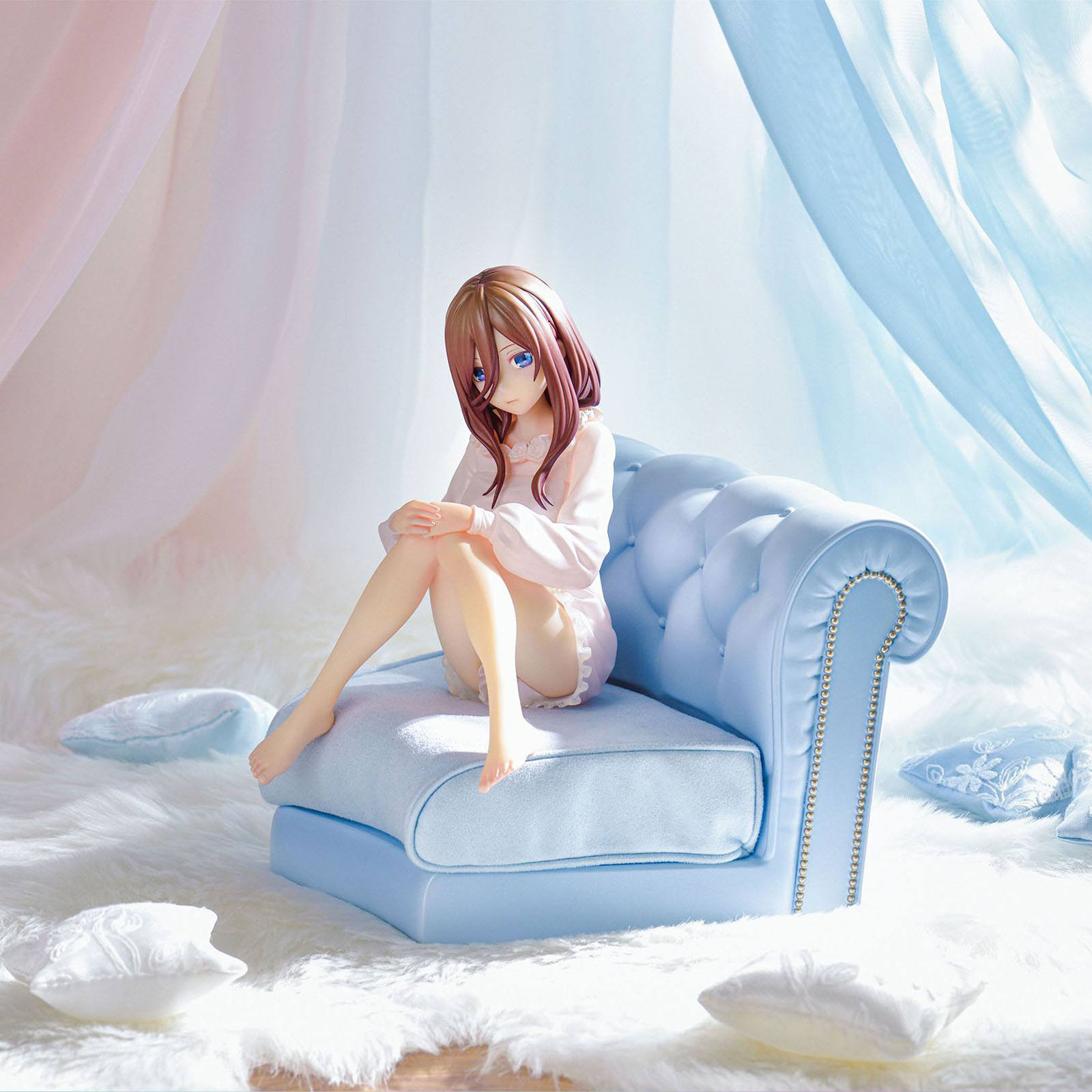 Eine Figur sitzt auf einem blauen Sofa, umgeben von weißen Kissen und flauschigem Teppich.
