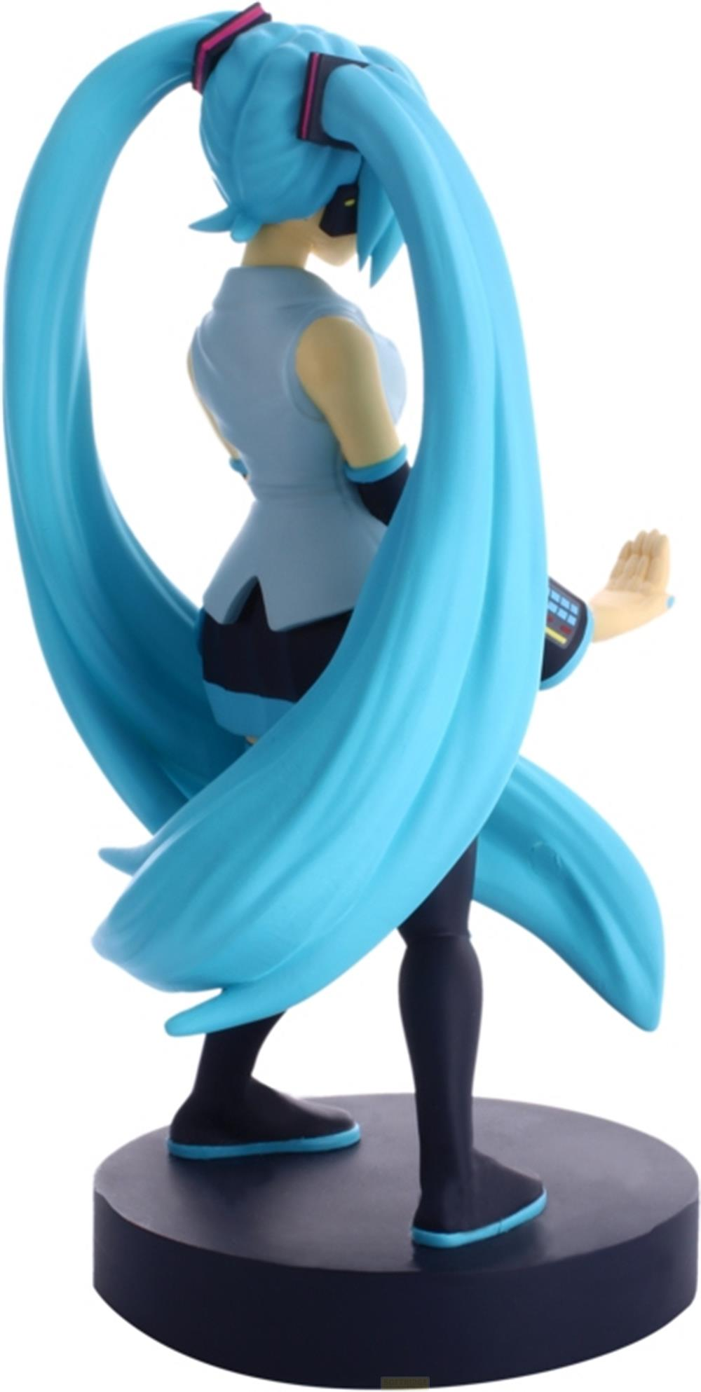 Una figura con lunghi capelli blu e un abito azzurro si erge su una base scura.