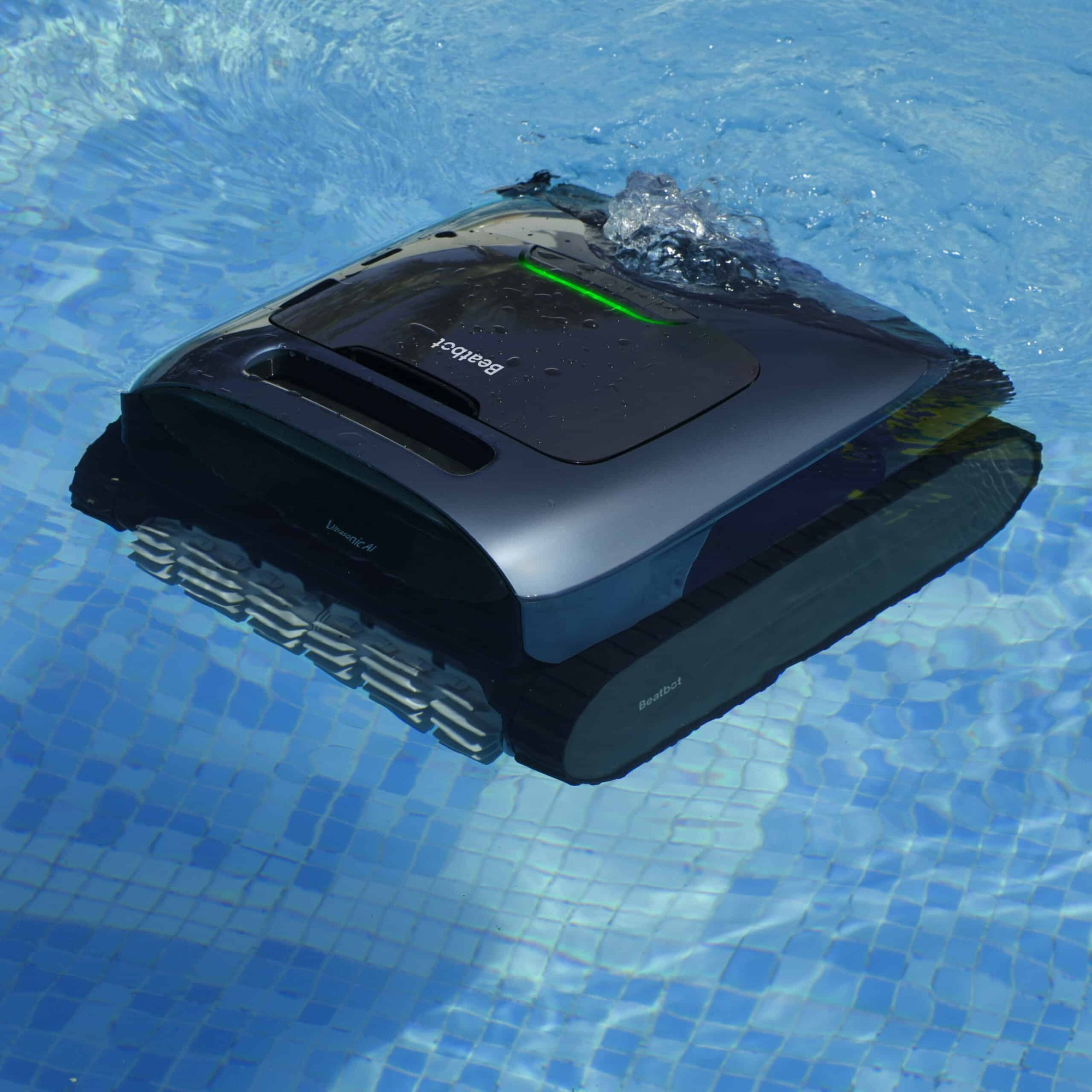 Ein dunkler Poolroboter mit Ketten fährt im blauen Poolwasser.