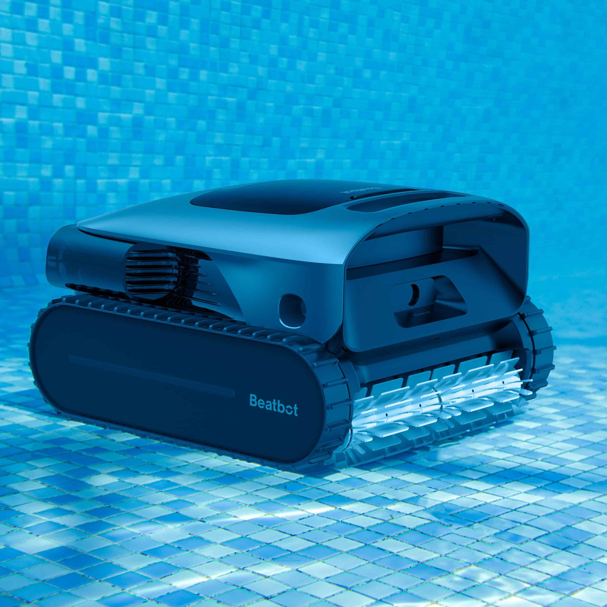 Ein dunkler Poolreiniger mit Ketten fährt auf einem blauen Kachelboden.