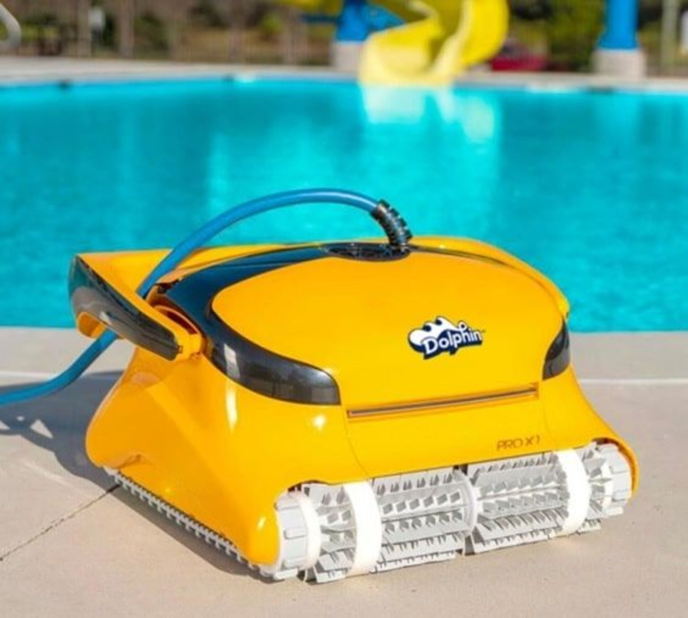 Un limpiafondos amarillo con manguera azul junto al borde de la piscina.