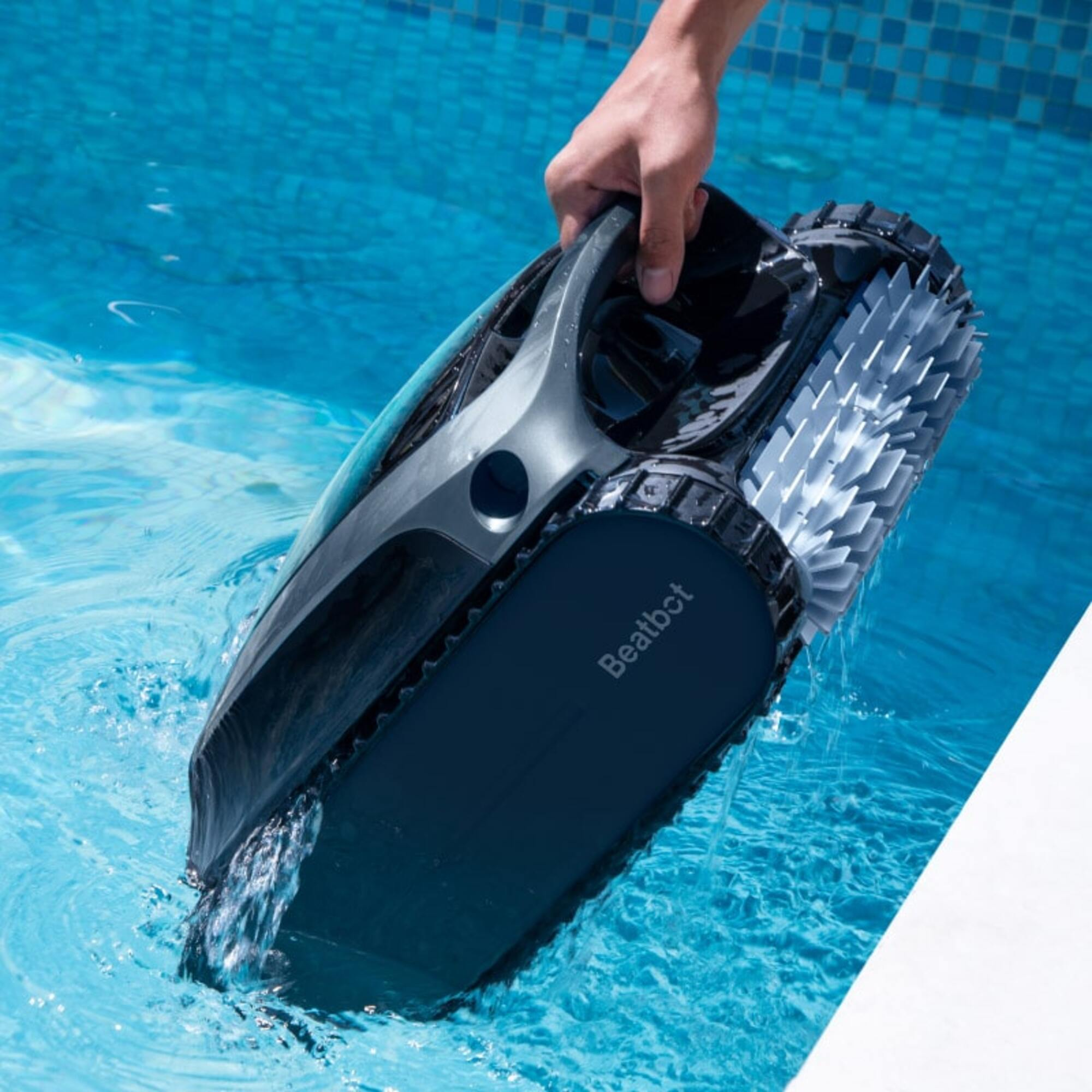 Ein Mann hebt einen schwarzen Poolroboter aus dem blauen Wasser.