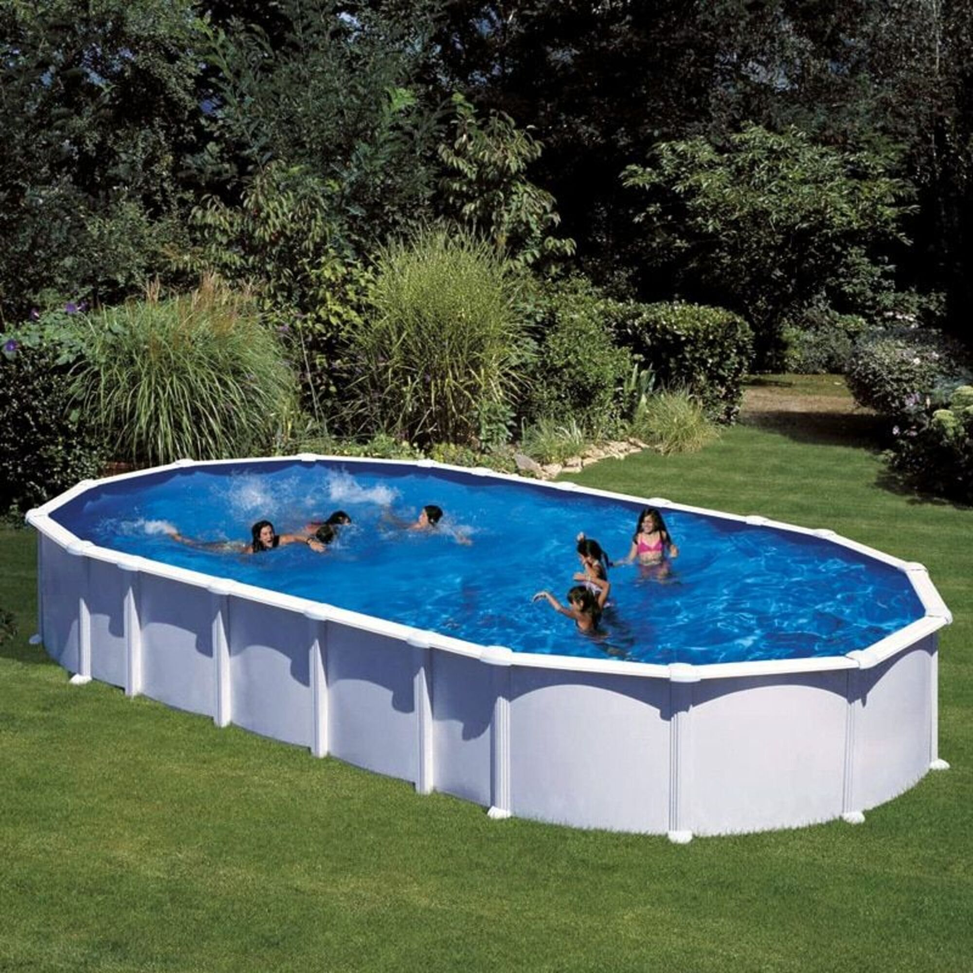 Niños juegan en una piscina ovalada en un jardín rodeado de verde.