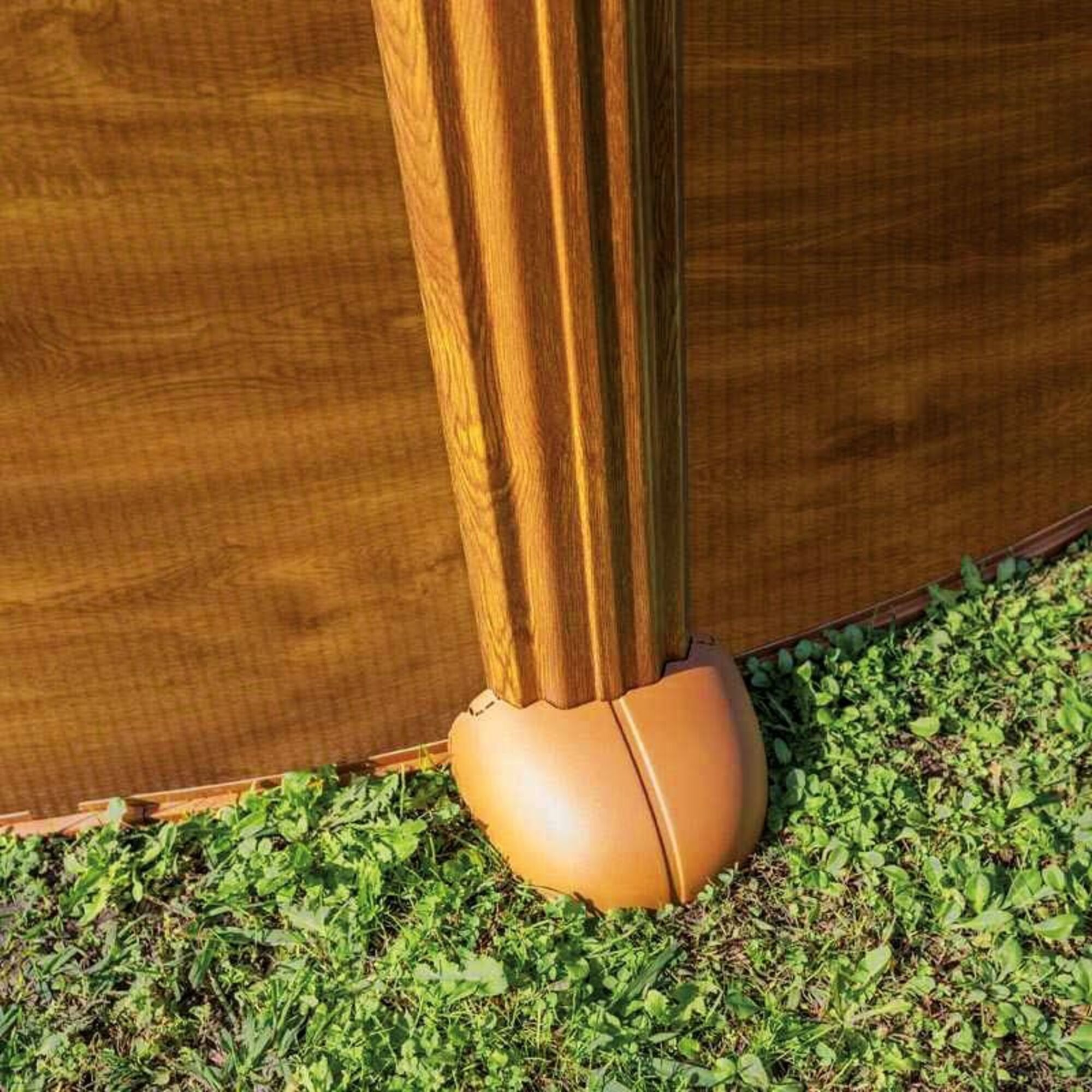 Un poste de madera marrón acanalado se alza sobre el suelo.