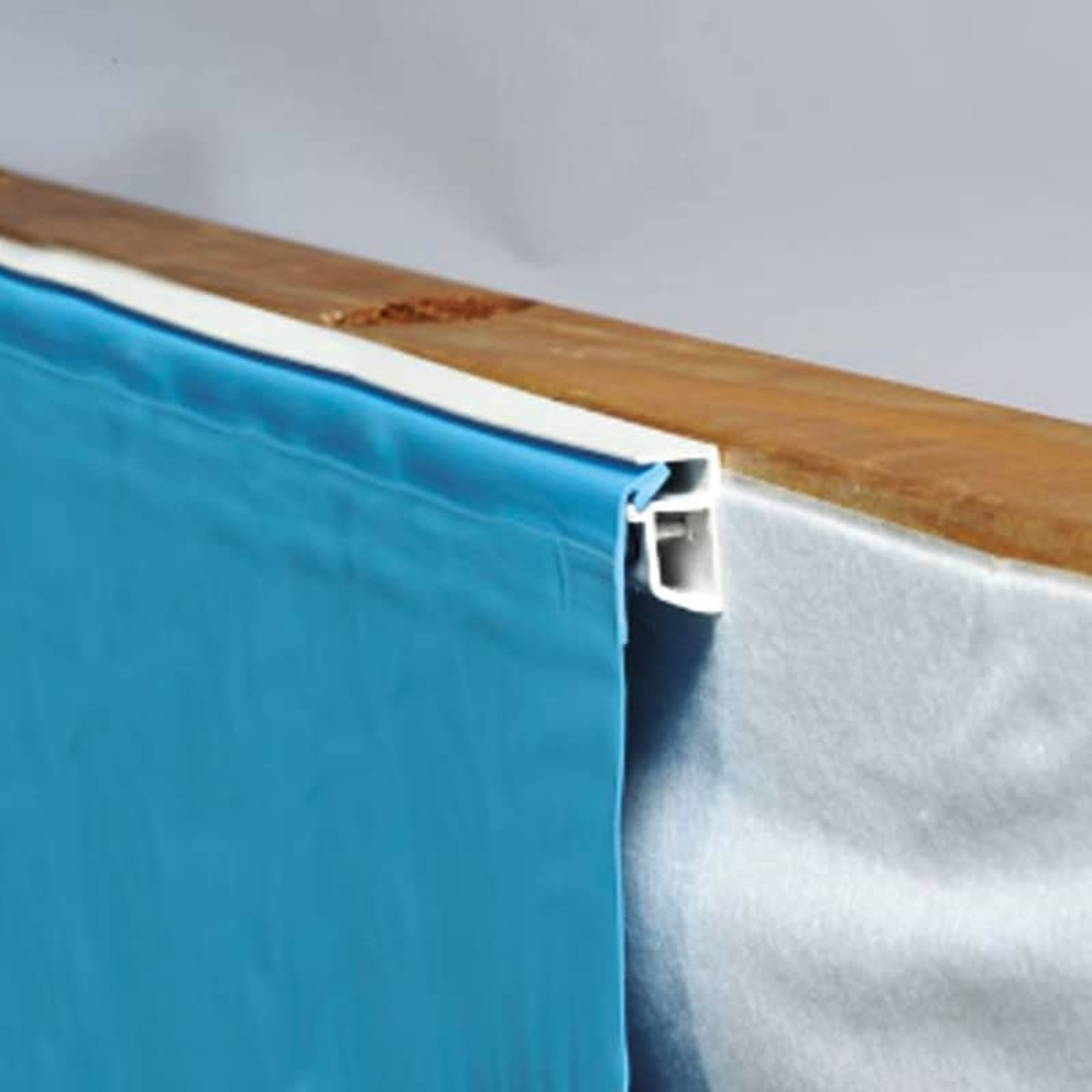 Tela azul con borde blanco sobre tabla de madera, primer plano.