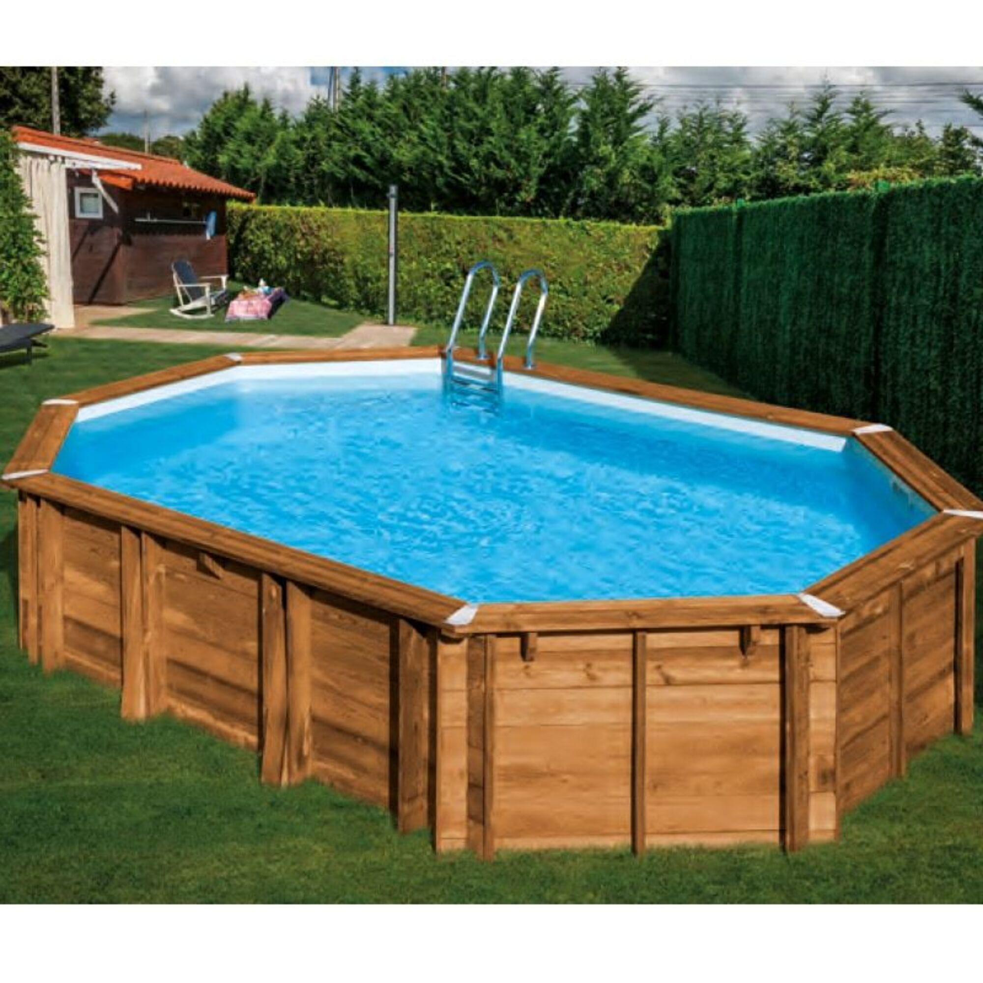 Piscina de madera con escalera, rodeada de césped y setos, con un pequeño cobertizo.