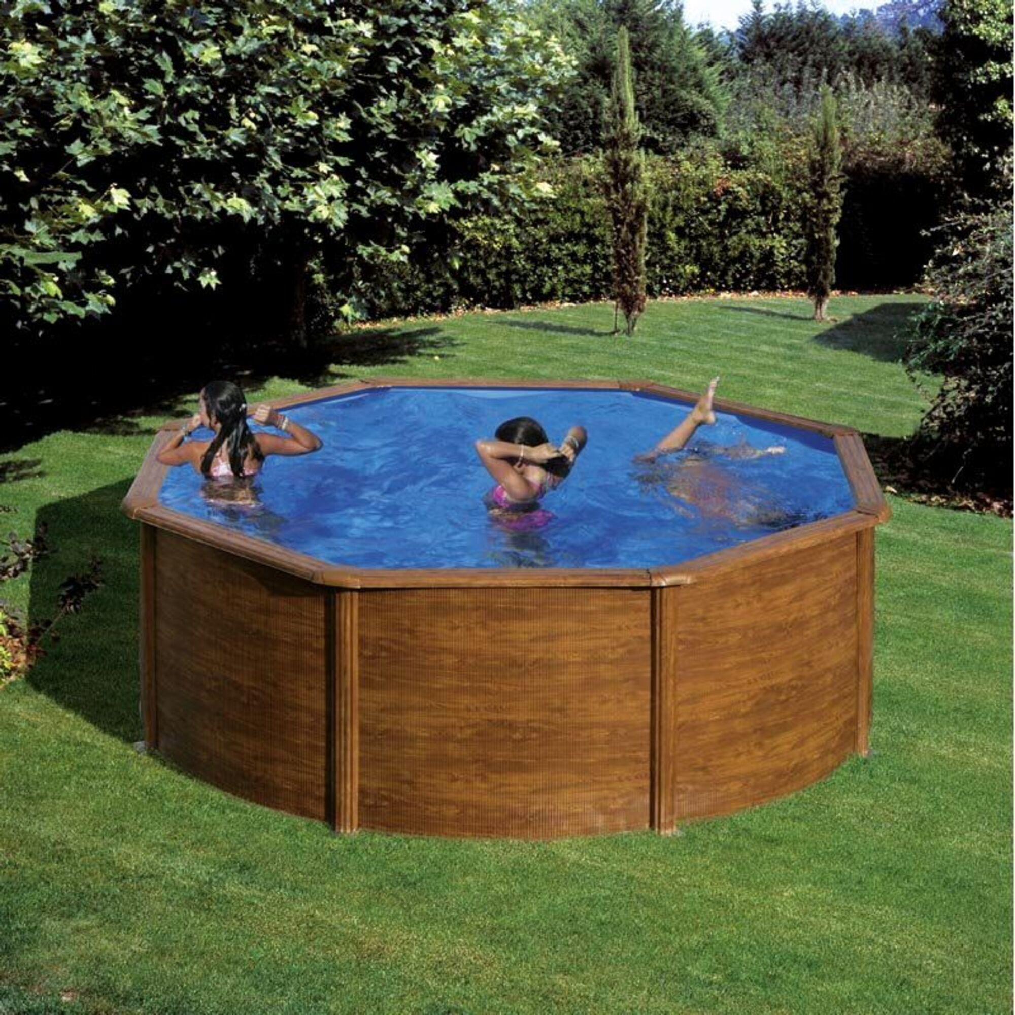 Tres personas chapotean en una piscina octogonal de aspecto de madera en un jardín.
