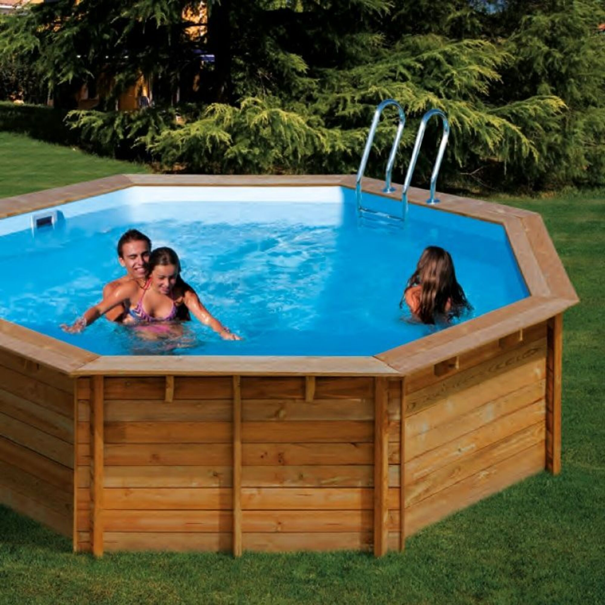 Tres personas en una piscina octogonal de madera en un día soleado.
