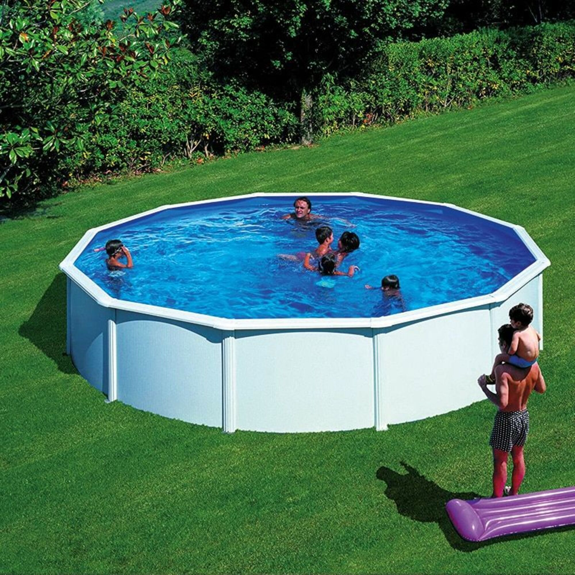 Una piscina octogonal con niños nadando y un hombre con un niño a hombros.
