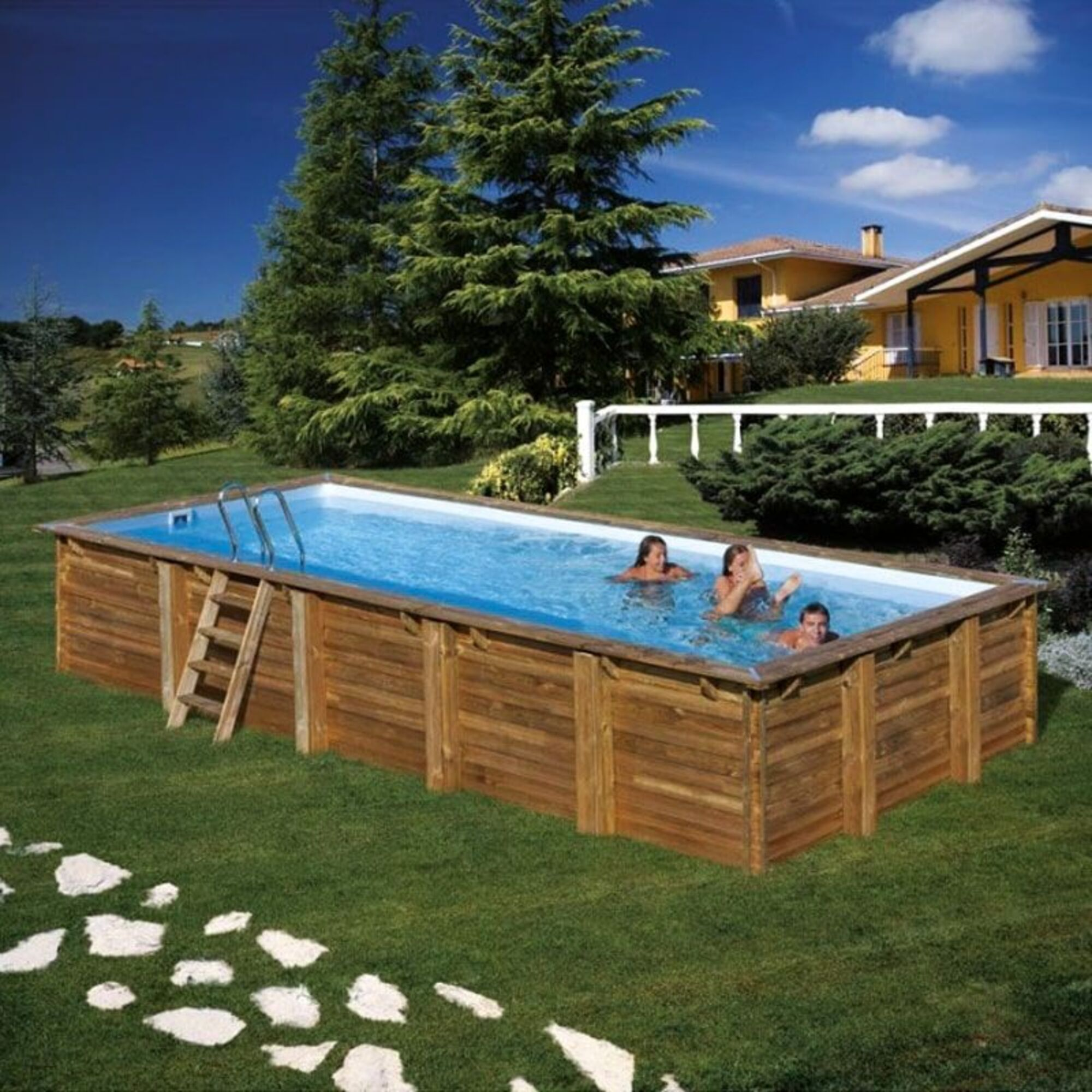 Piscina de madera con escaleras y tres personas en el agua, rodeada de verde.