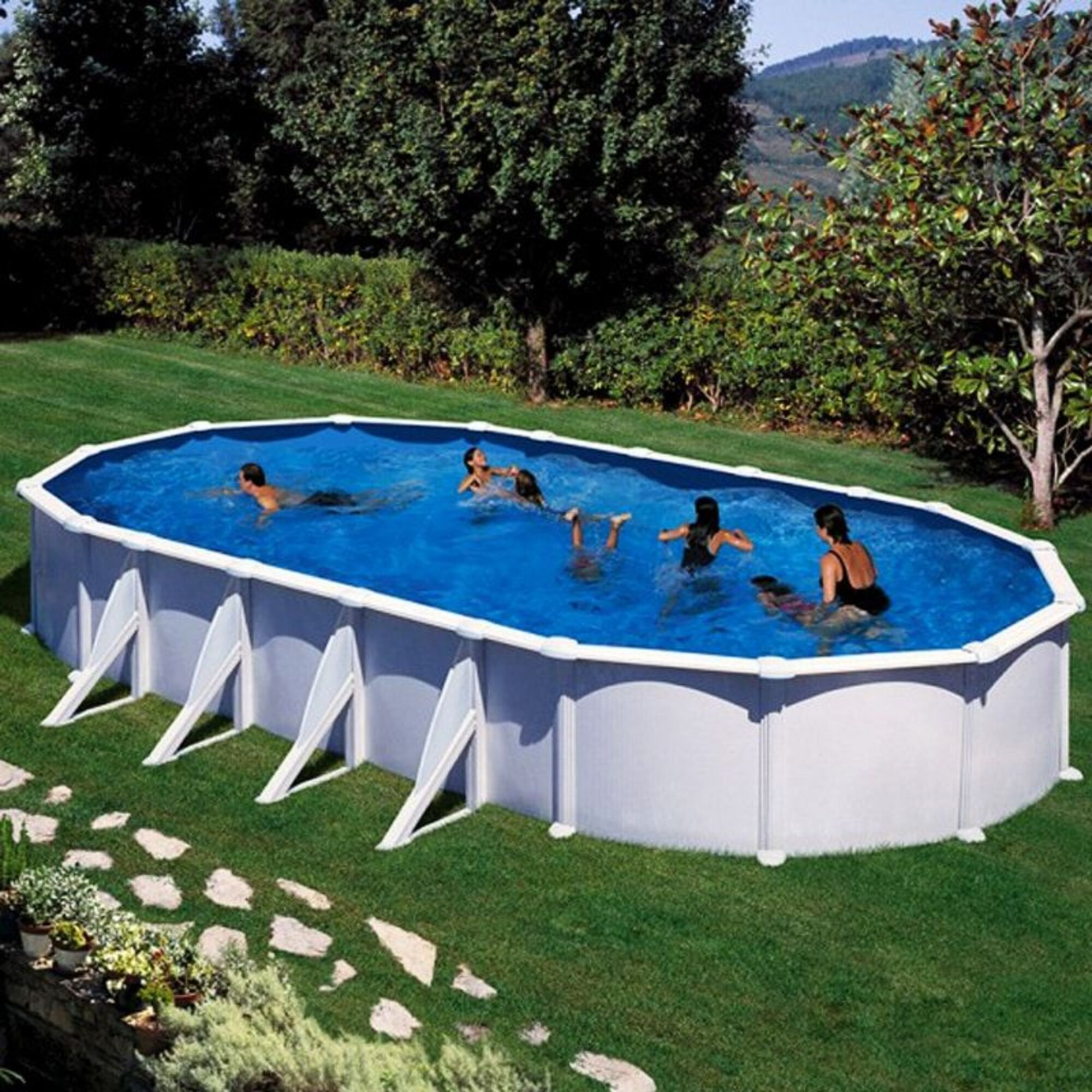 Varias personas chapotean en una piscina ovalada en el patio trasero. Árboles y colinas al fondo.