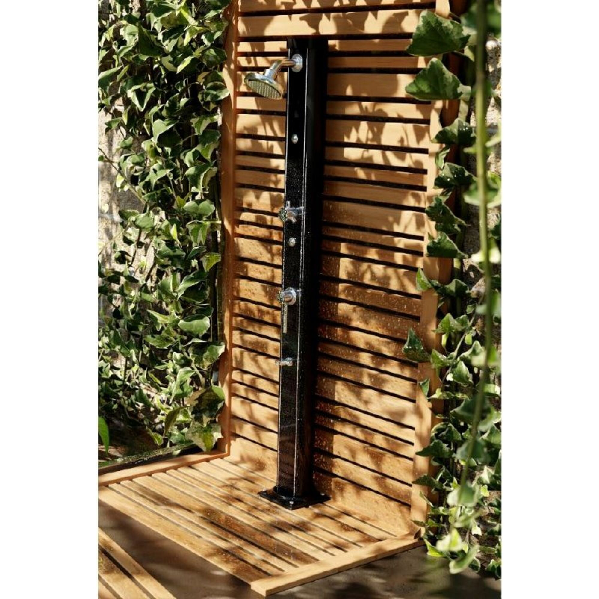 Una ducha exterior negra se alza sobre una tarima de madera con paredes de madera.