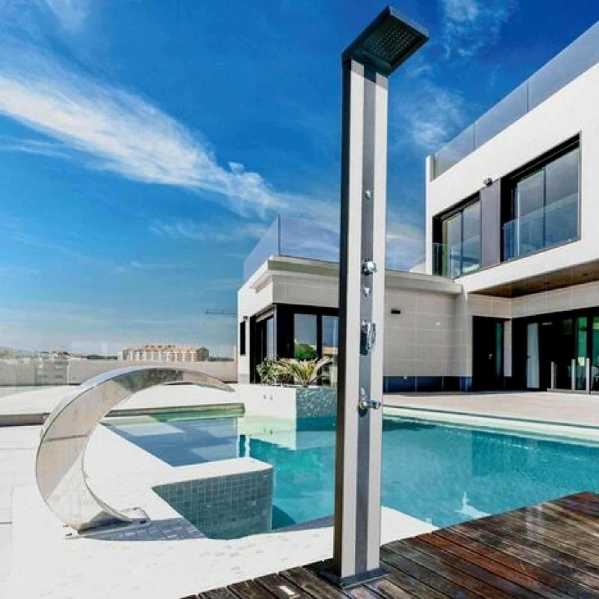 Zona exterior moderna con piscina, ducha, escultura y villa.