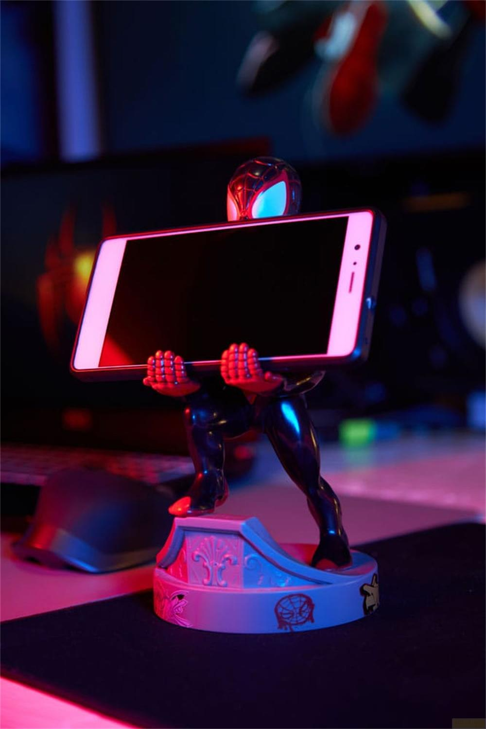 Una figura di Miles Morales tiene uno smartphone, illuminato in rosso e blu.