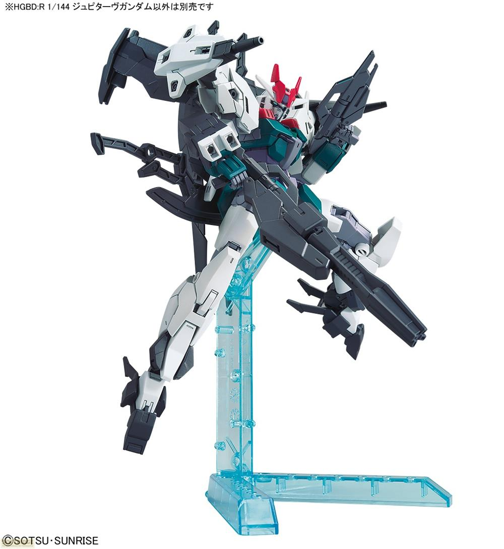 Un robot Gundam blanc, gris et sarcelle tient une arme sur un support d'exposition bleu.