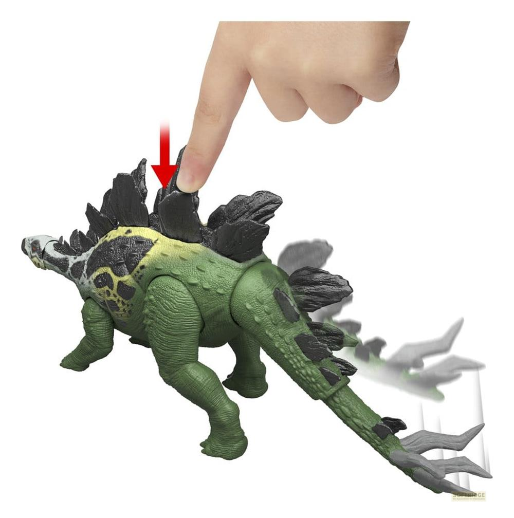 Grüner Dinosaurier-Spielzeug mit schwarzen Platten, Finger drückt auf Knopf.