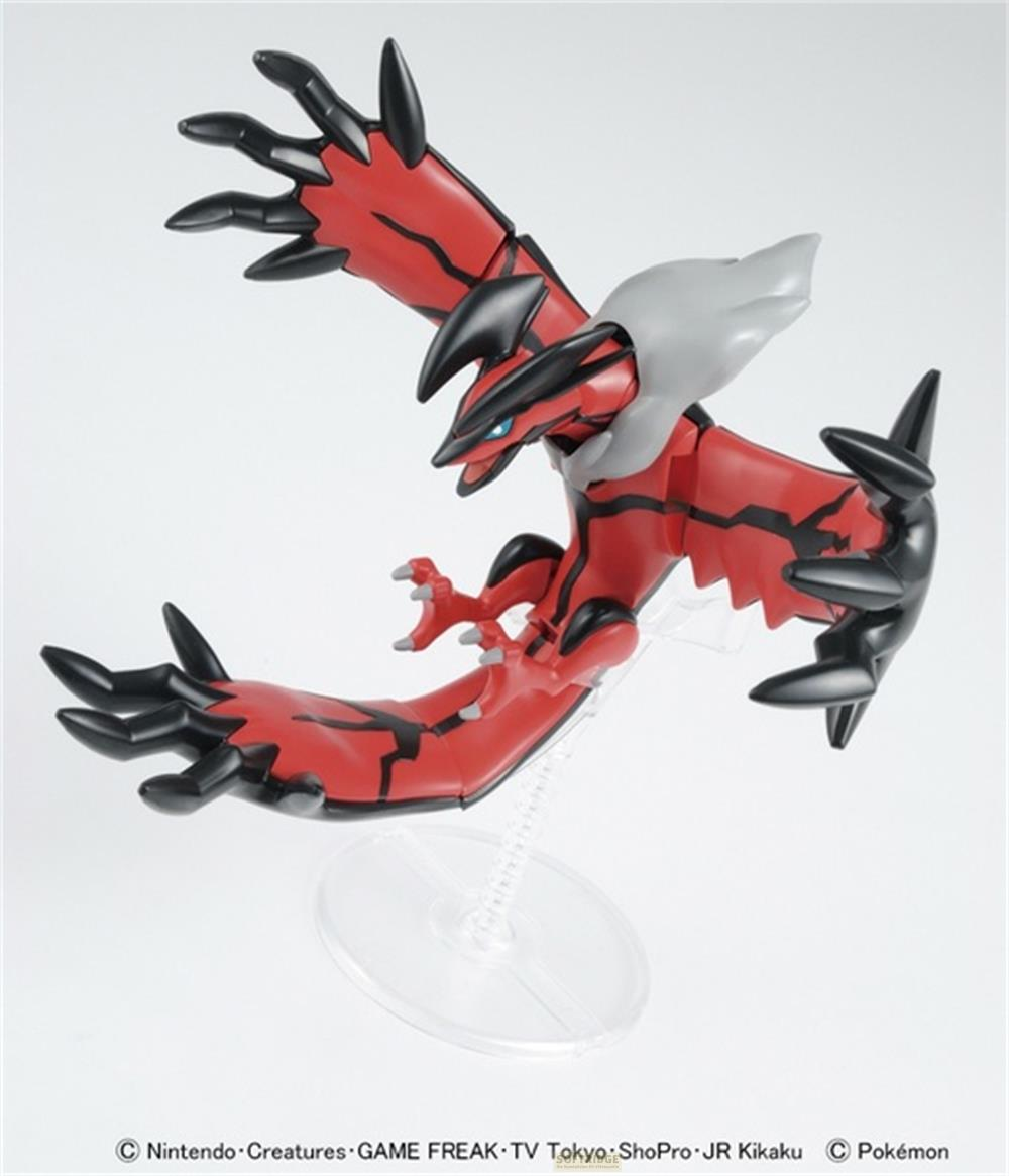 Figurine Pokémon rouge et noire avec griffes acérées et ailes, en vol sur un support.