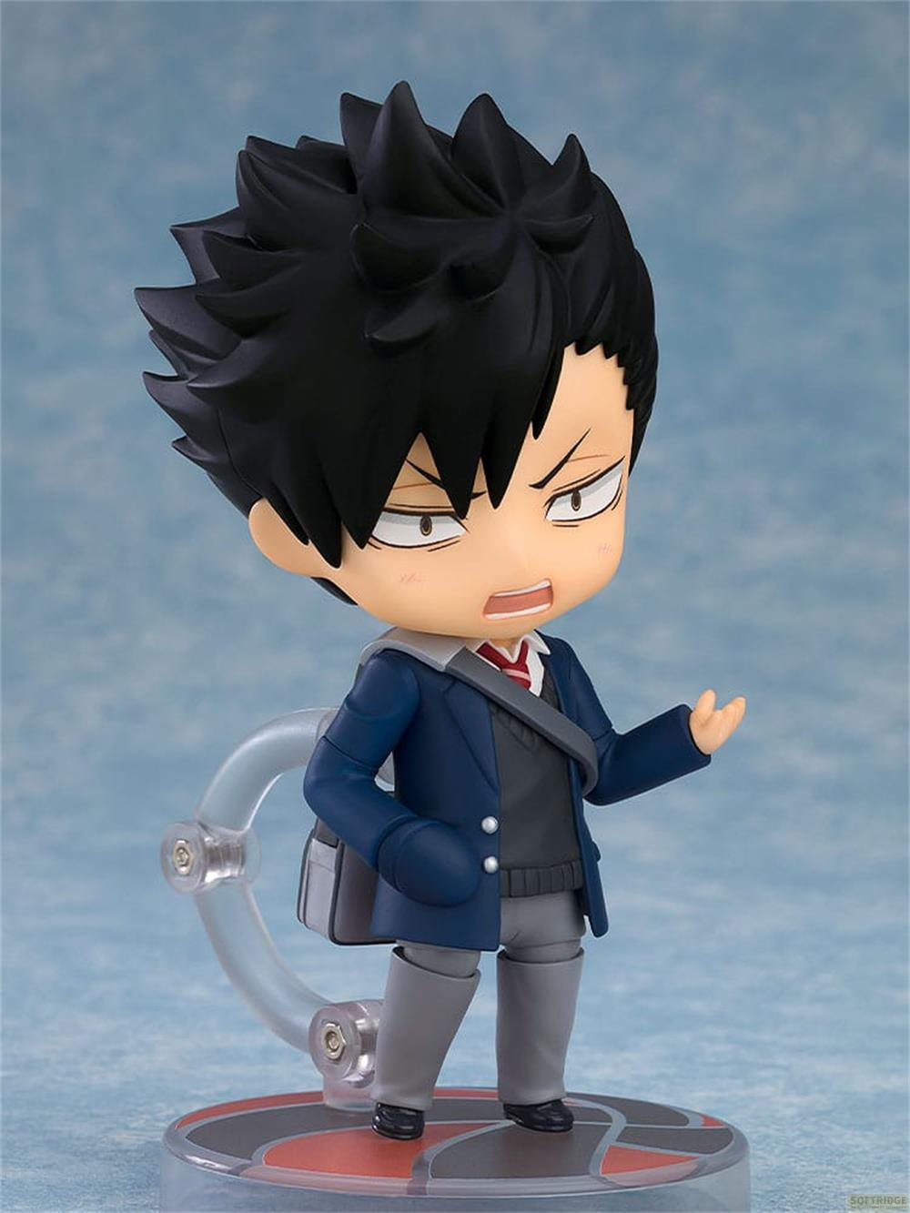 Figura de anime de un chico con pelo negro, chaqueta azul, pantalones grises y bolso cruzado.