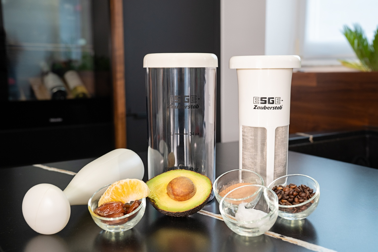 Handmixer mit Zutaten: Avocado, Datteln, Orange, Zimt, Kaffee, Eiswürfel.