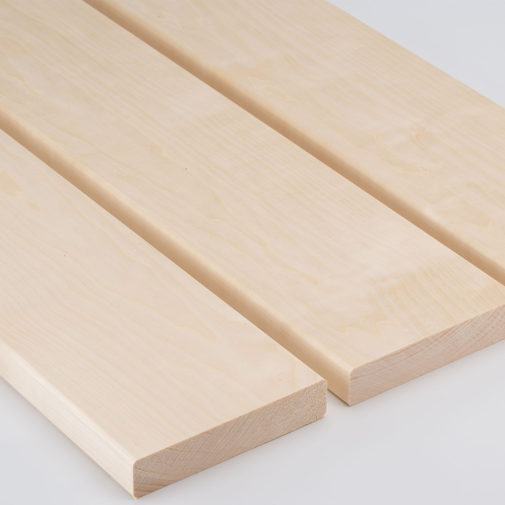 Drei helle Holzbretter liegen nebeneinander, mit feiner Maserung und abgerundeten Kanten.