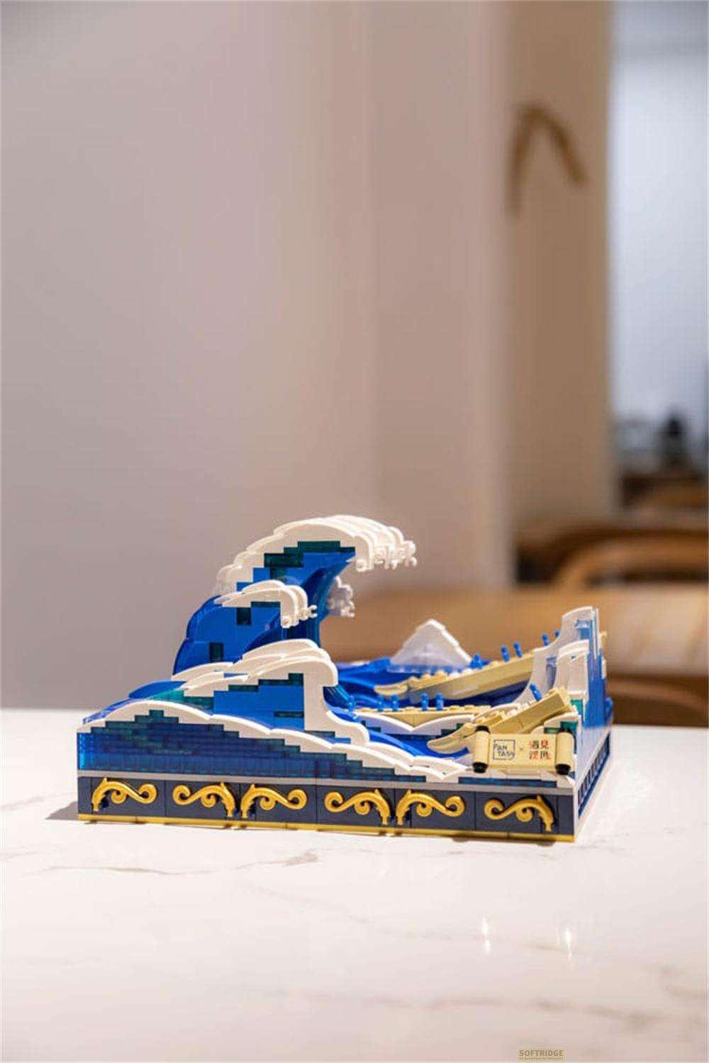 Maquette Lego d'une vague bleue avec des crêtes d'écume blanches et de petits bateaux.