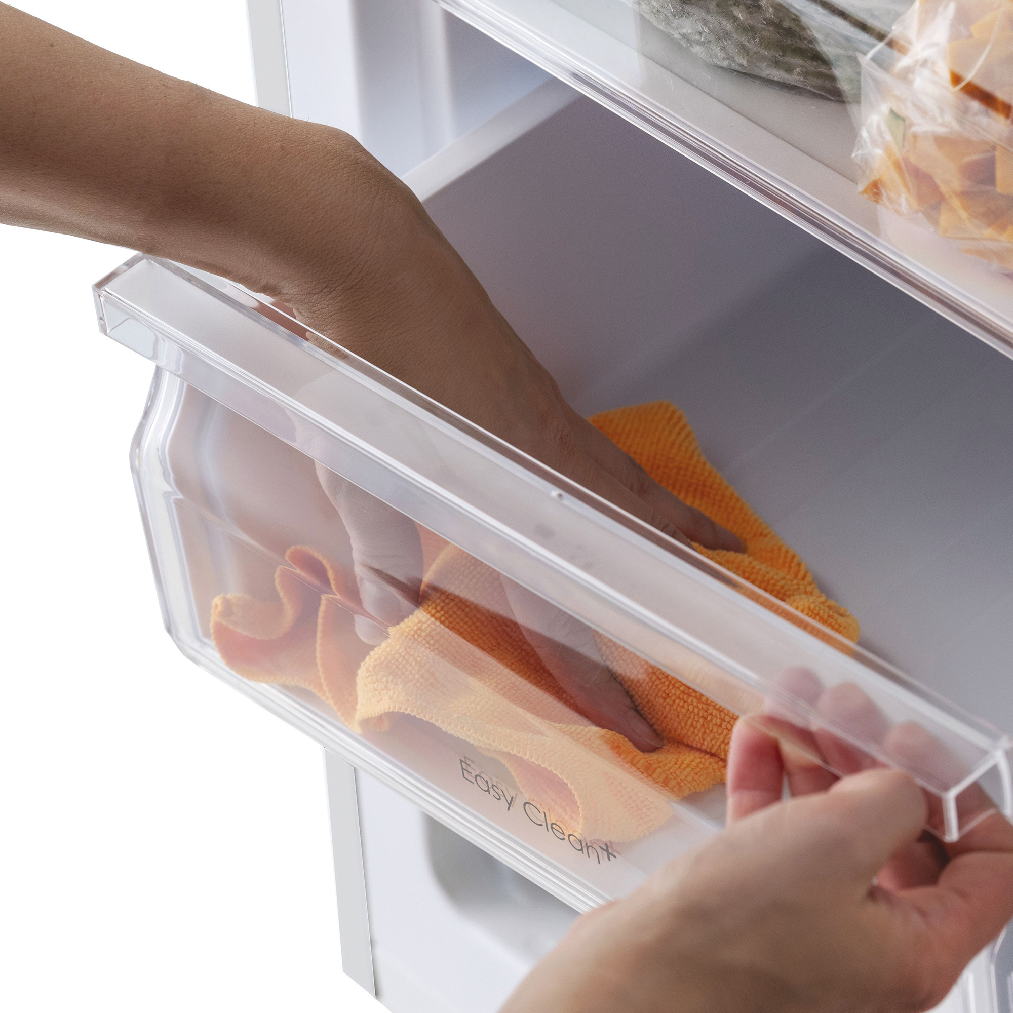 Eine Hand reinigt mit einem orangen Tuch eine Schublade im Kühlschrank.