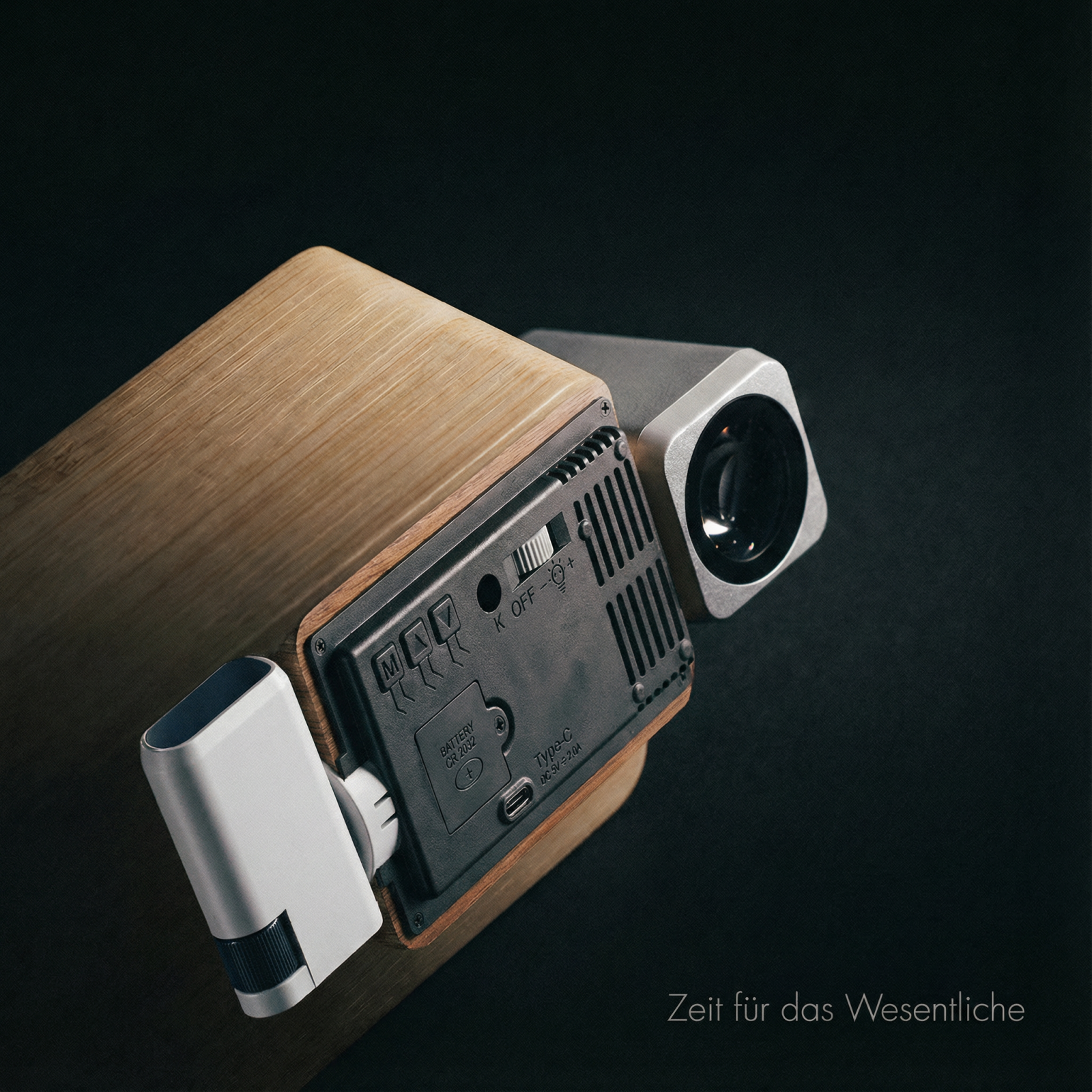 Ein Projektor mit Holzgehäuse und silbernen Details auf schwarzem Grund.