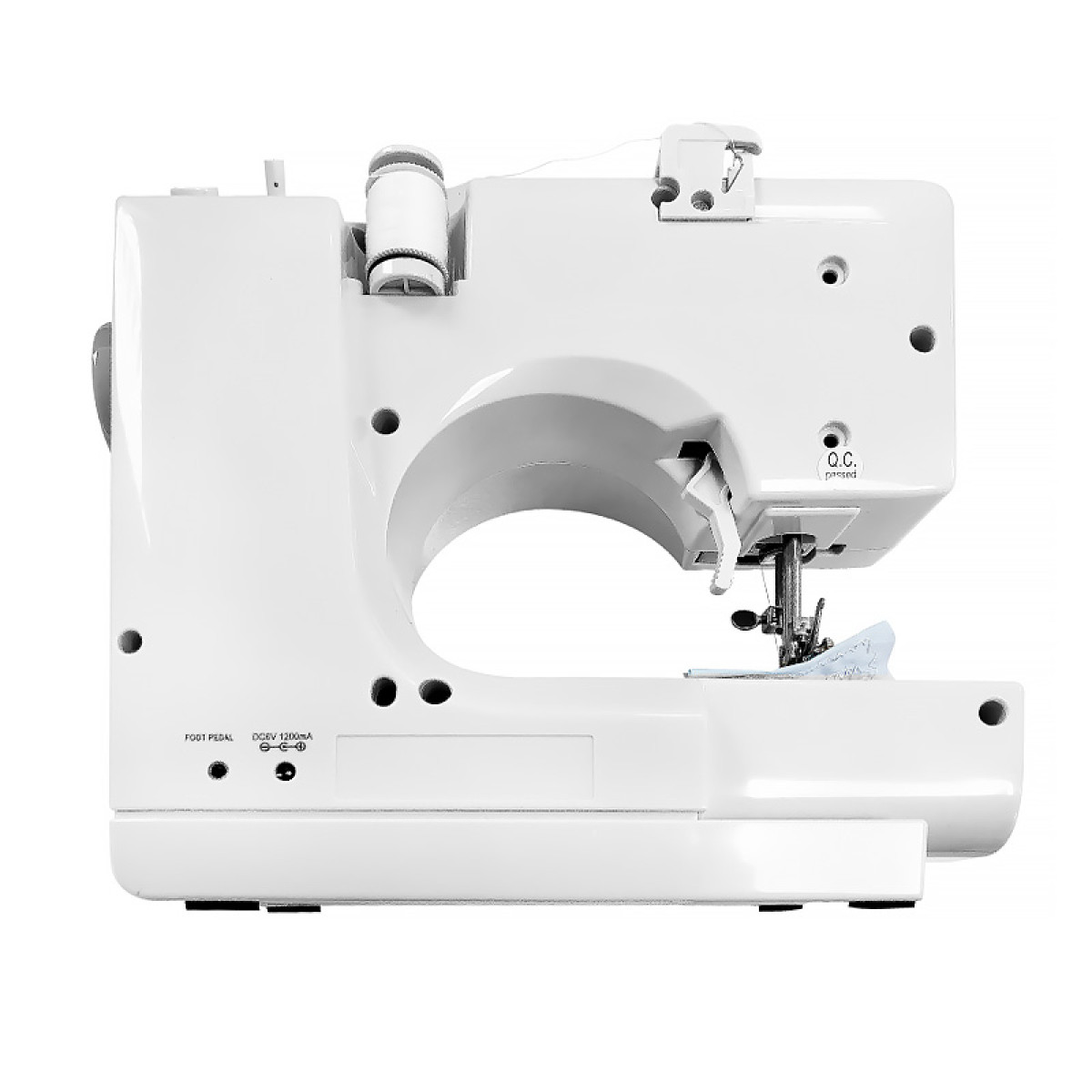 Biała maszyna do szycia z motkiem nici, igłą i tkaniną.