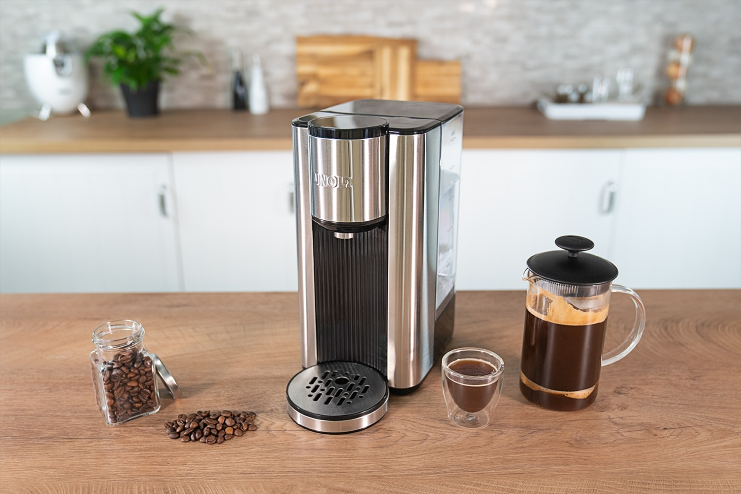 Eine Kaffeemaschine mit Kaffeebohnen, einem kleinen Glas Espresso und einer French Press.
