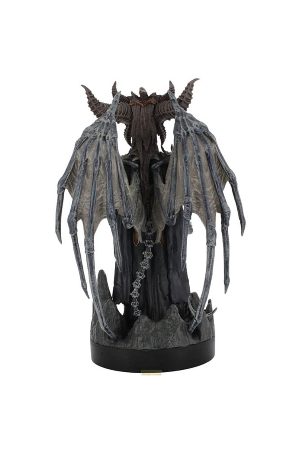 Une figure sombre avec de grandes ailes et des cornes se tient sur une base rocheuse.