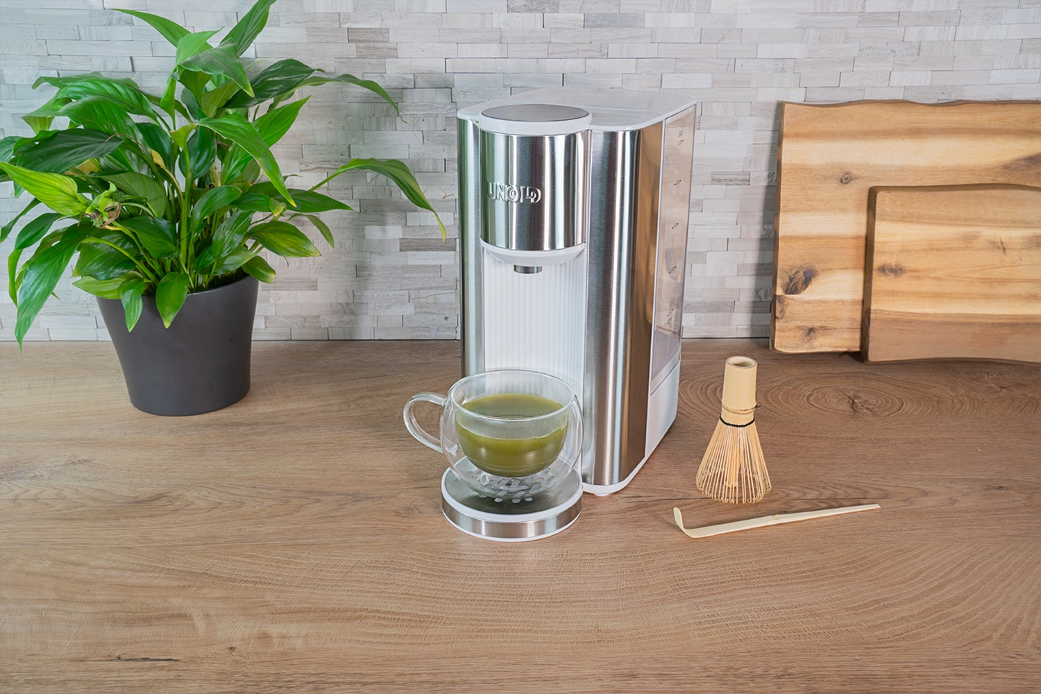 Ein grüner Tee-Bereiter mit einer Tasse, Bambusbesen und Löffel.
