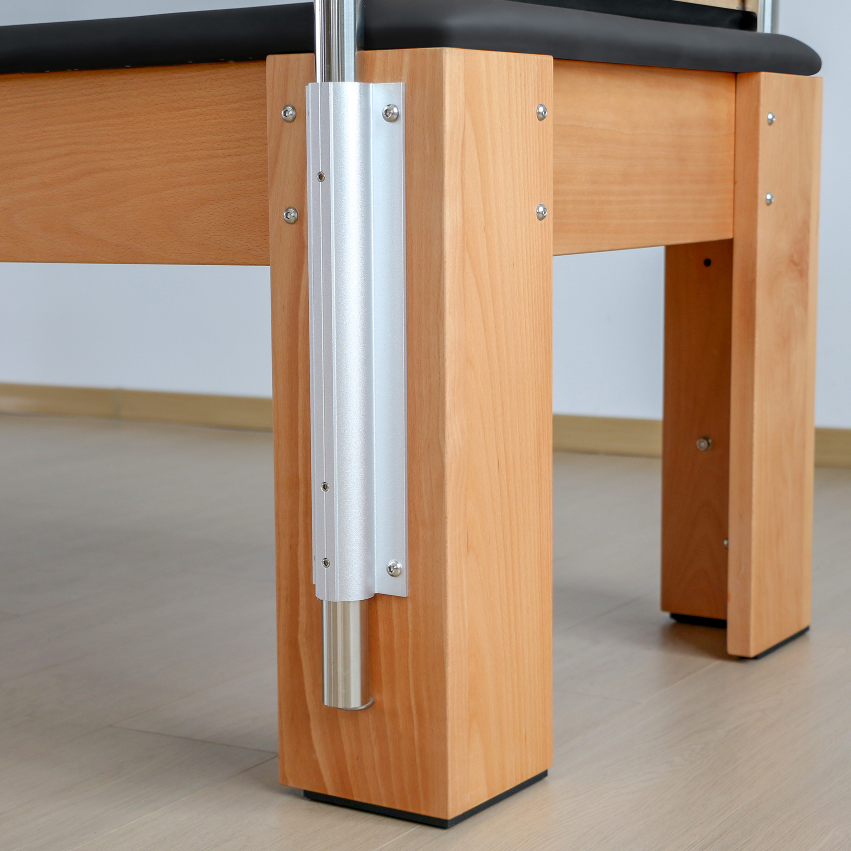 Holzbeine eines Tisches mit silbernen Metallverzierungen und schwarzem Obermaterial.