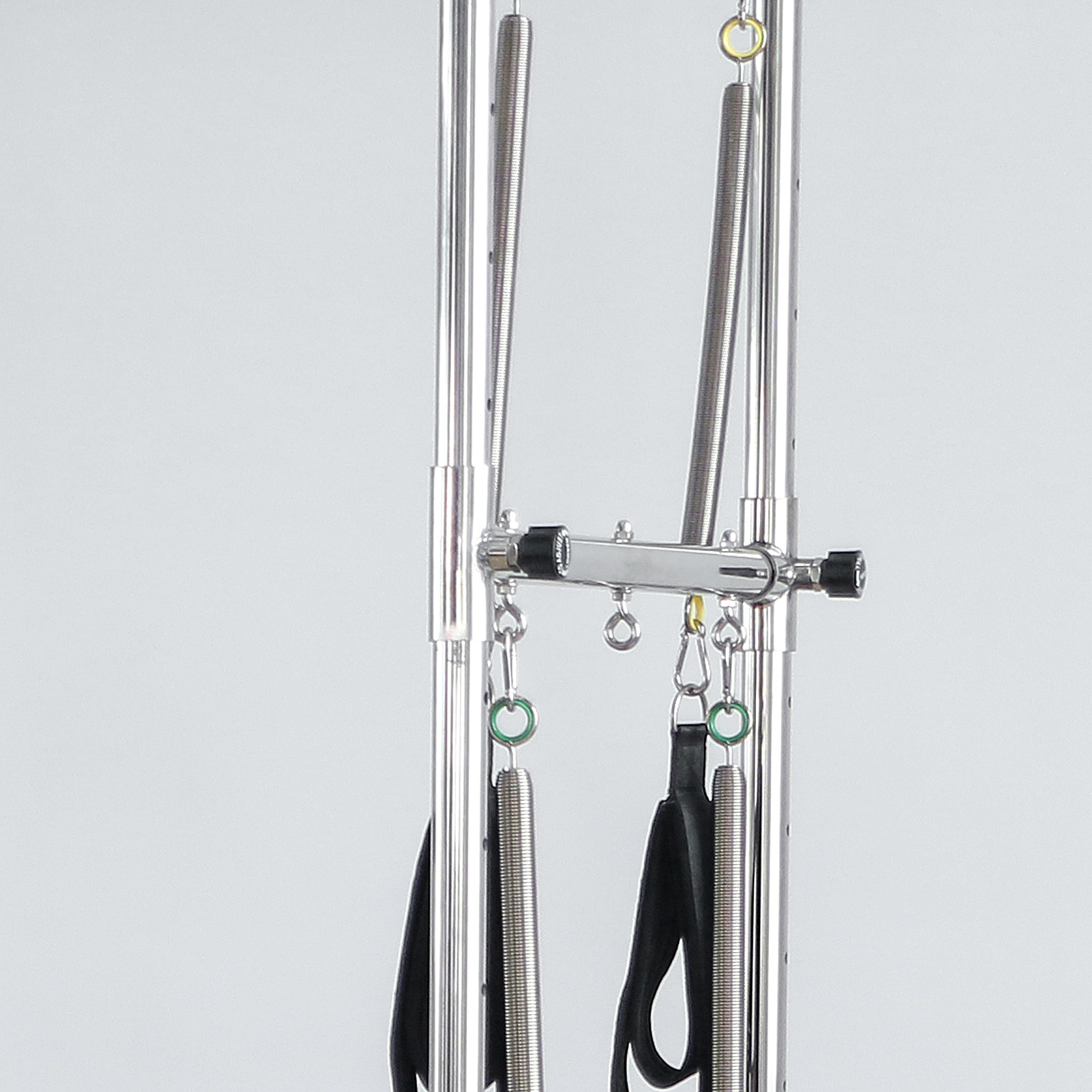 Pilates Reformer-Teil mit Federn, Riemen und Metallstangen.