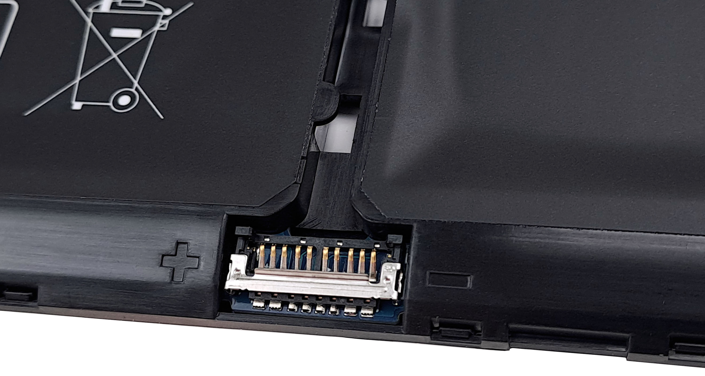 Zbliżenie złącza baterii laptopa i symbolu recyklingu.