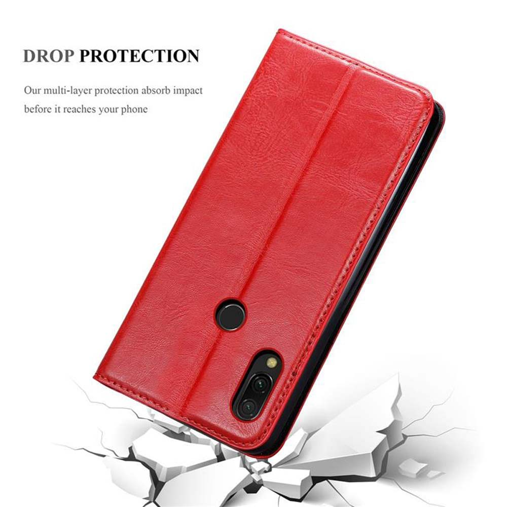 Custodia rossa a libro per telefono su terreno crepato.