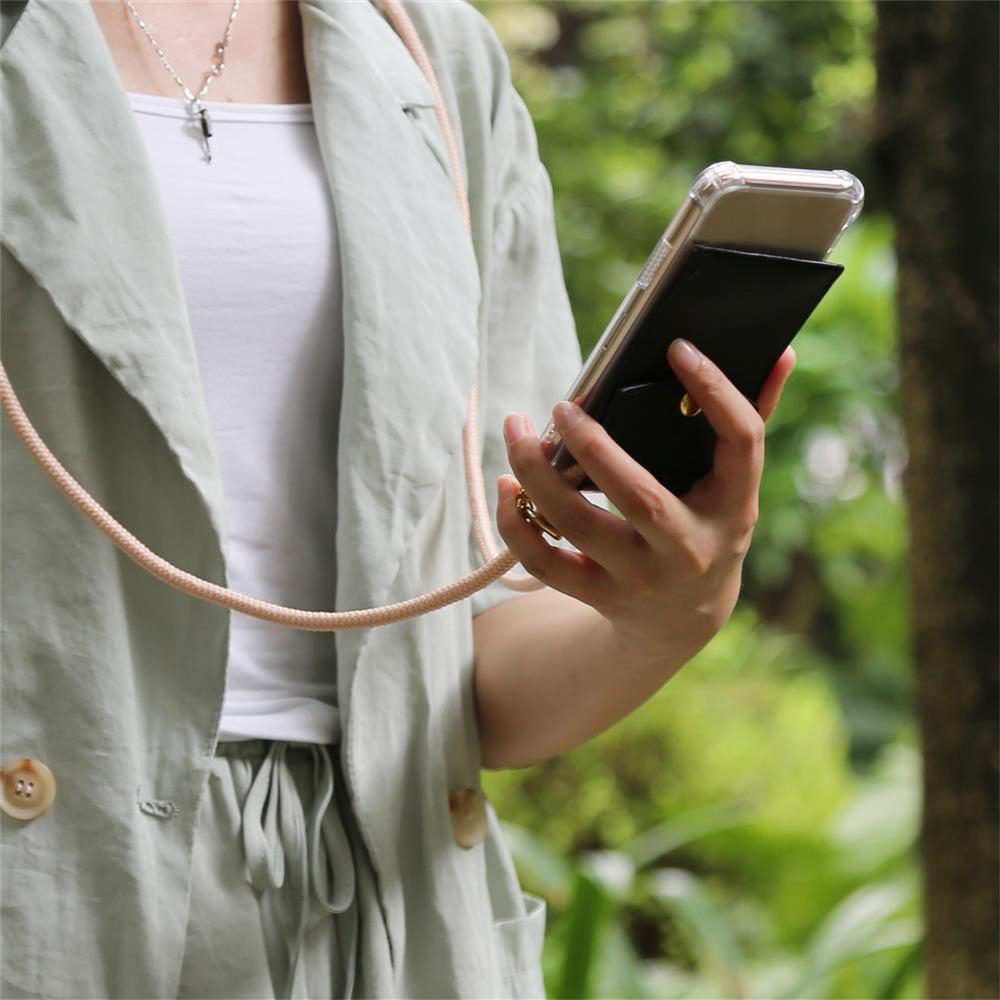 Una persona tiene uno smartphone con un portafoglio nero e un anello porta telefono.