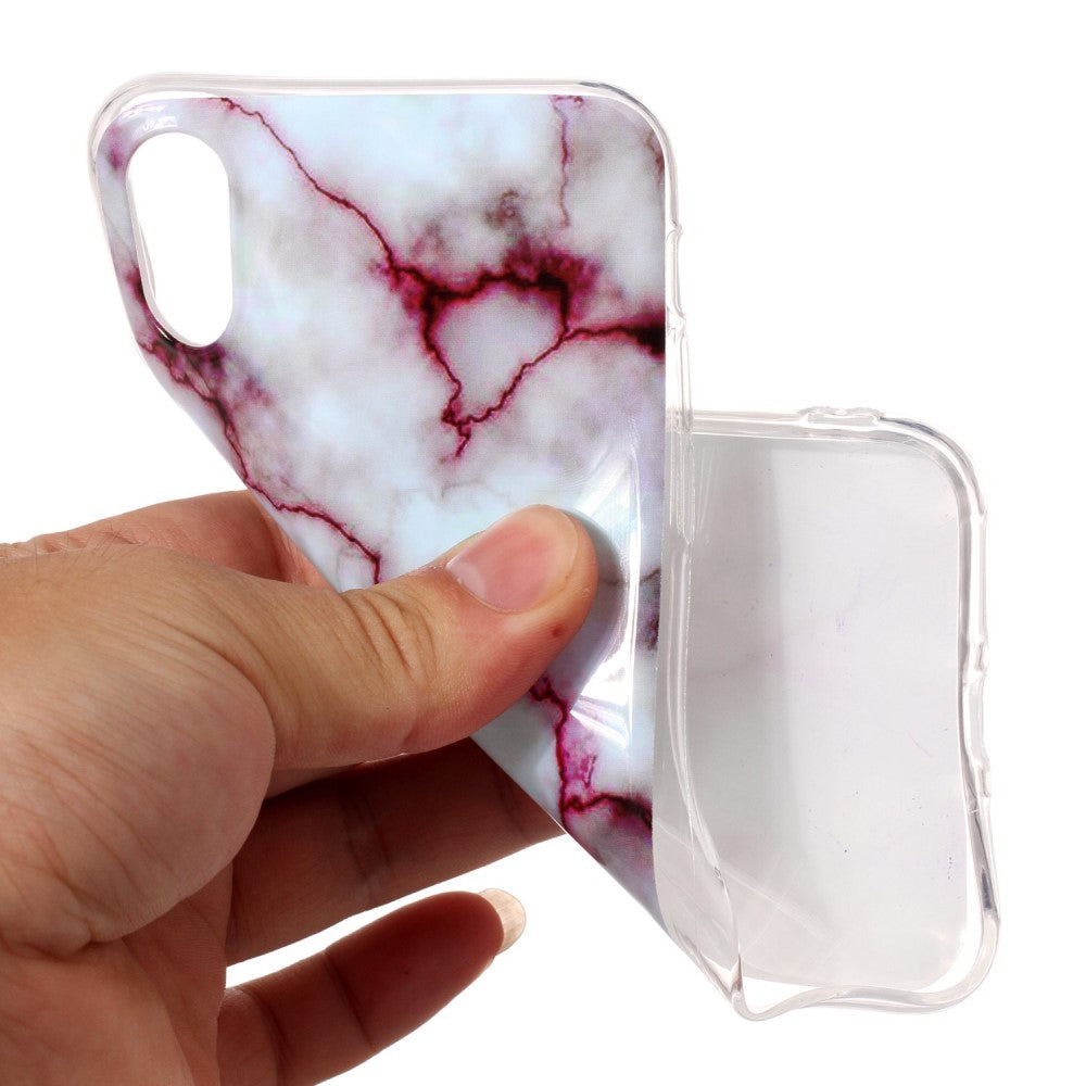 Mano che tiene una cover per telefono marmorizzata con venature rosse.