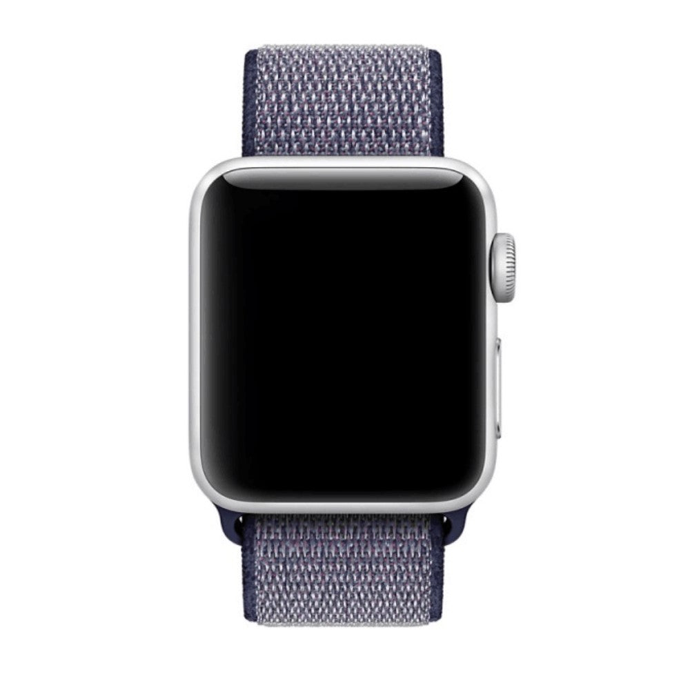 Uno smartwatch argentato con cinturino in tessuto blu su sfondo bianco.